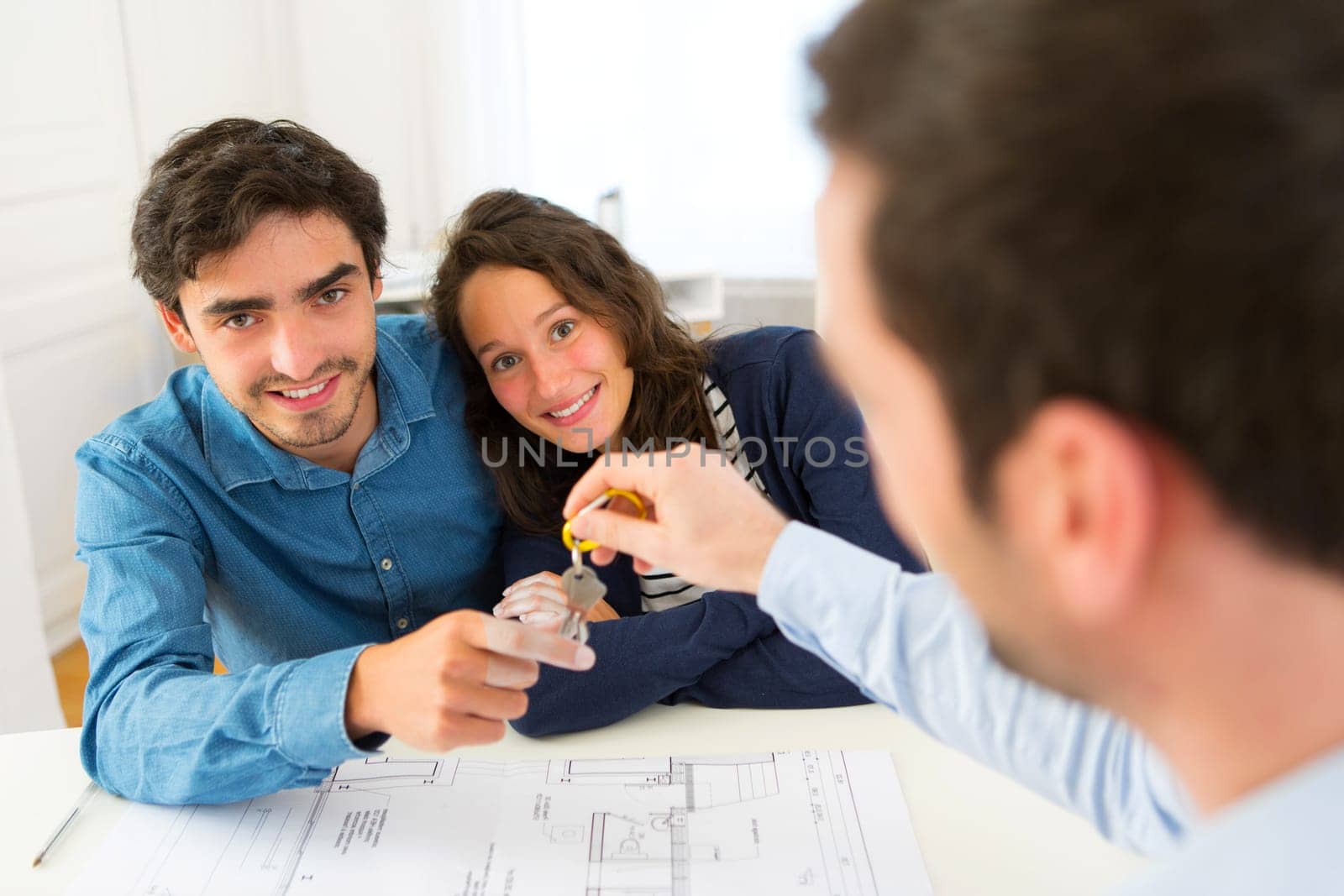 View of a Real estate handing over keys to couple