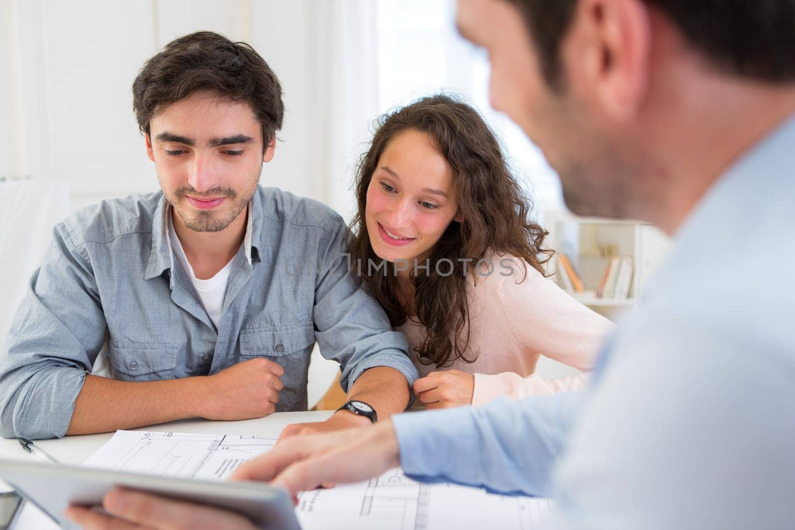 View of a young relaxed couple meeting a real estate agent