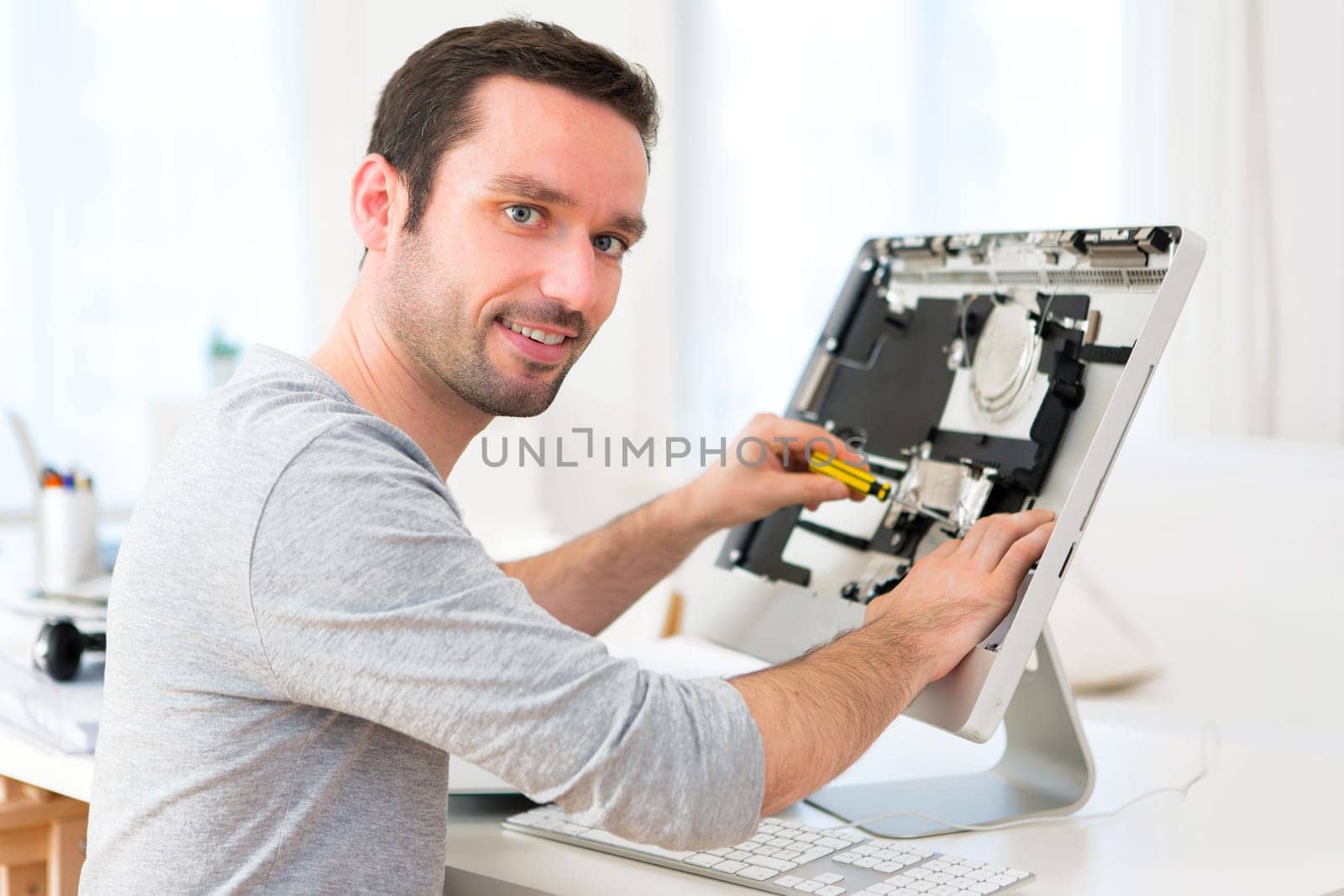 View of a Young attractive man repairing a computer