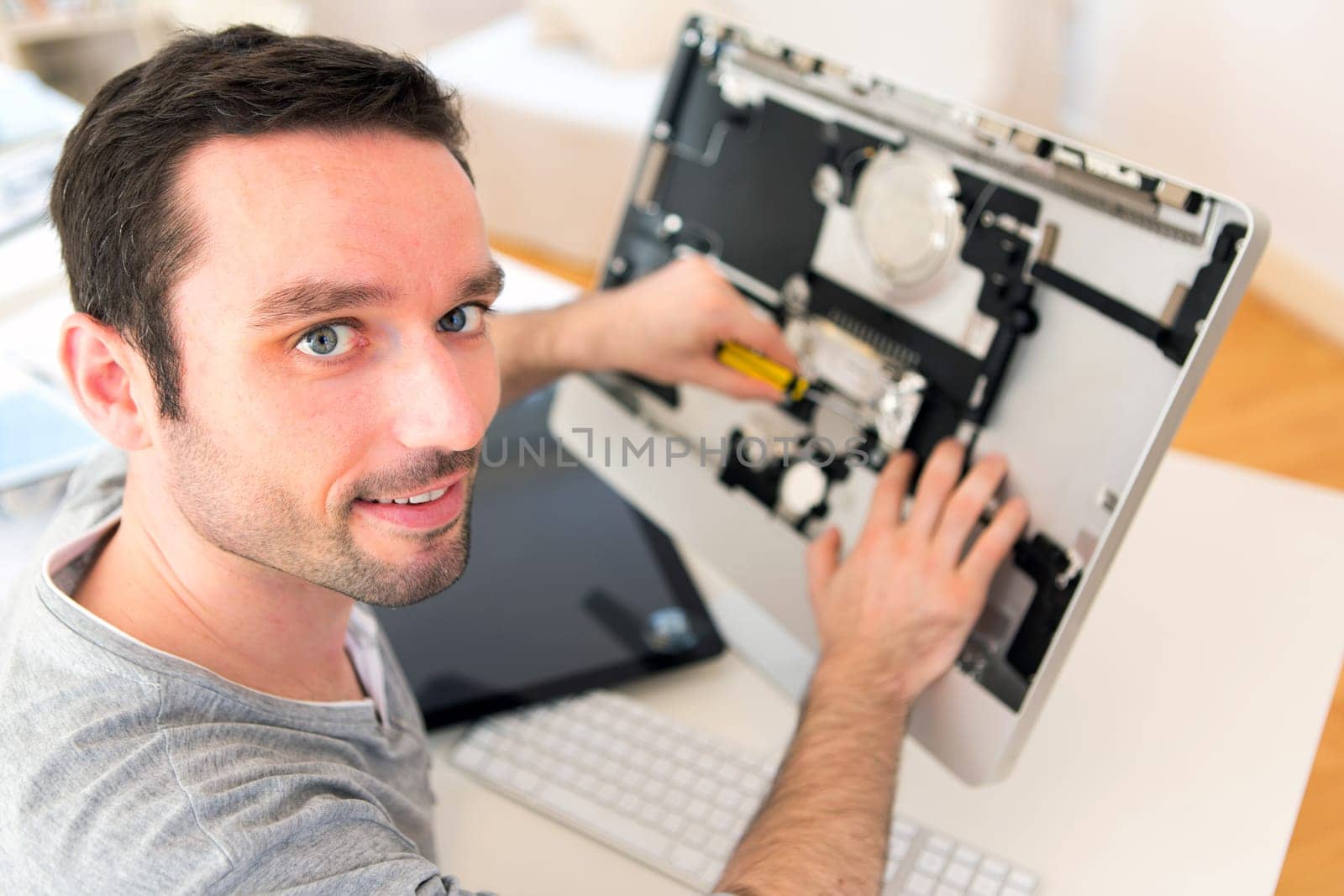 View of a Young attractive man repairing a computer