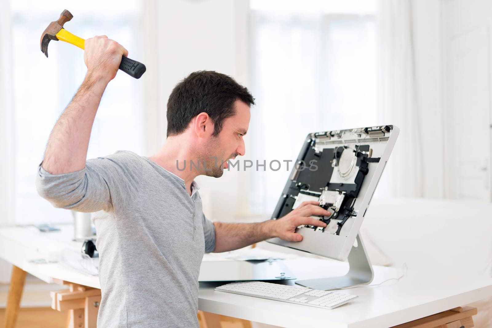 View of a Young attractive man angry against computer