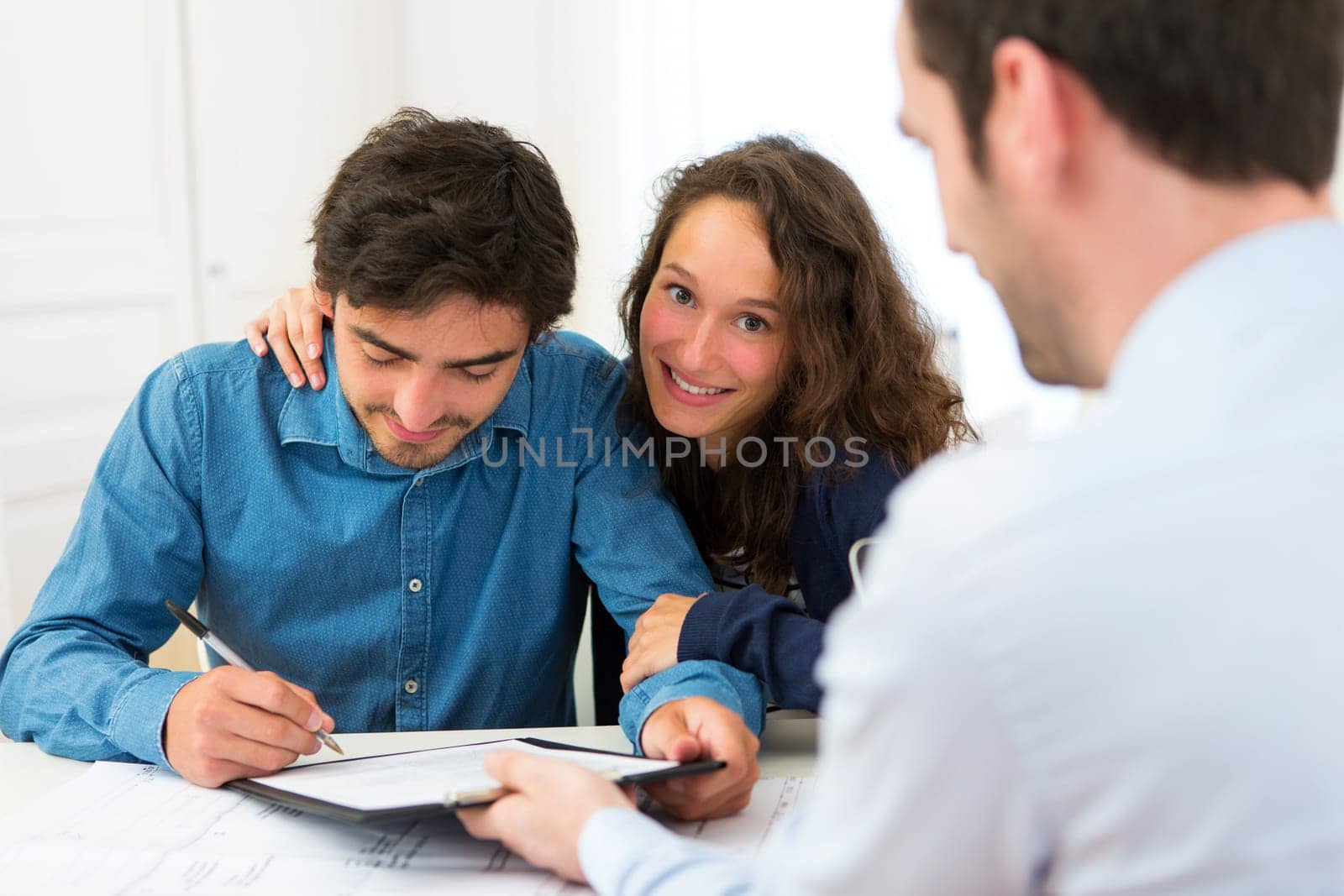 View of a Young attractive couple signing contract