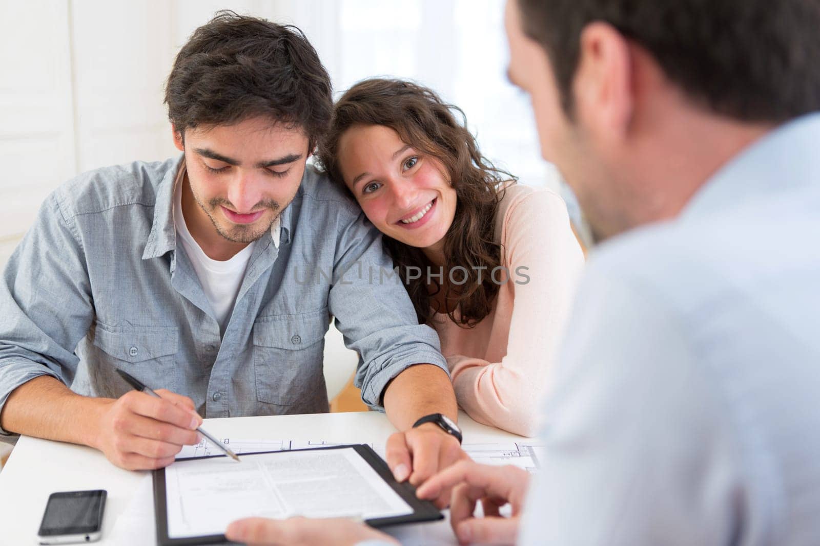 View of a Young attractive couple signing contract