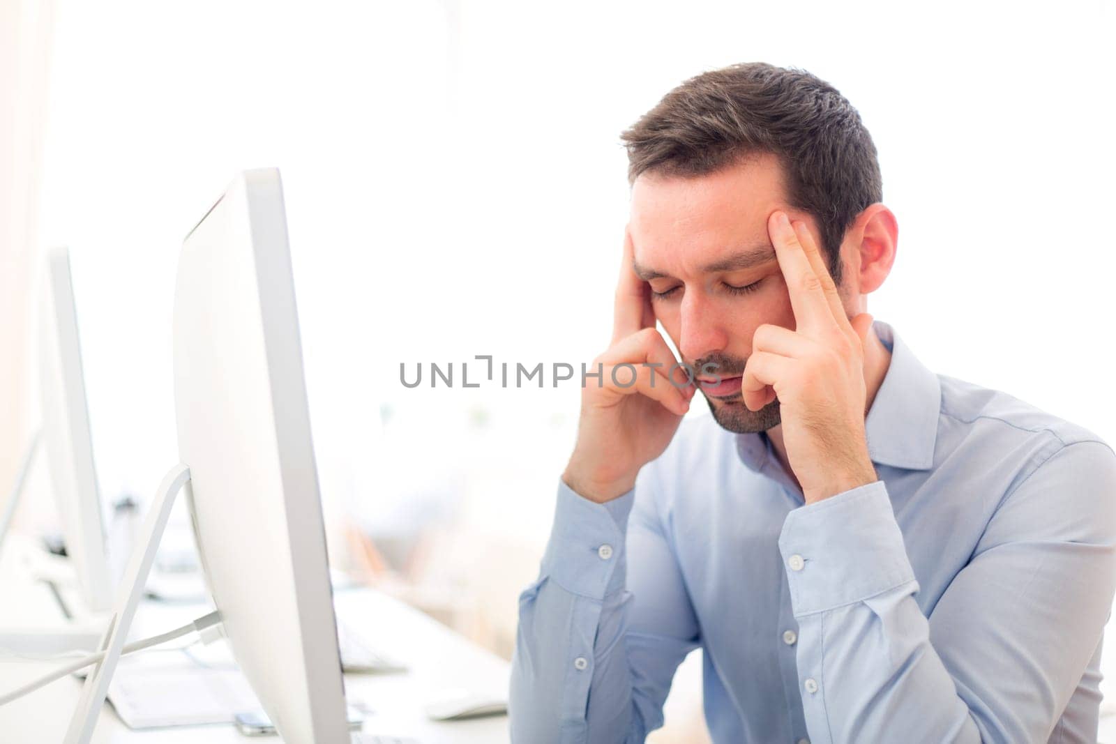 View of a Young attractive man got a headache at the office