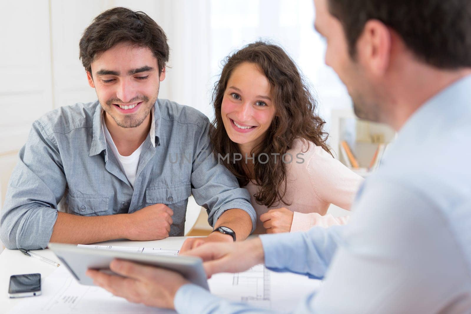 View of a young relaxed couple meeting a real estate agent