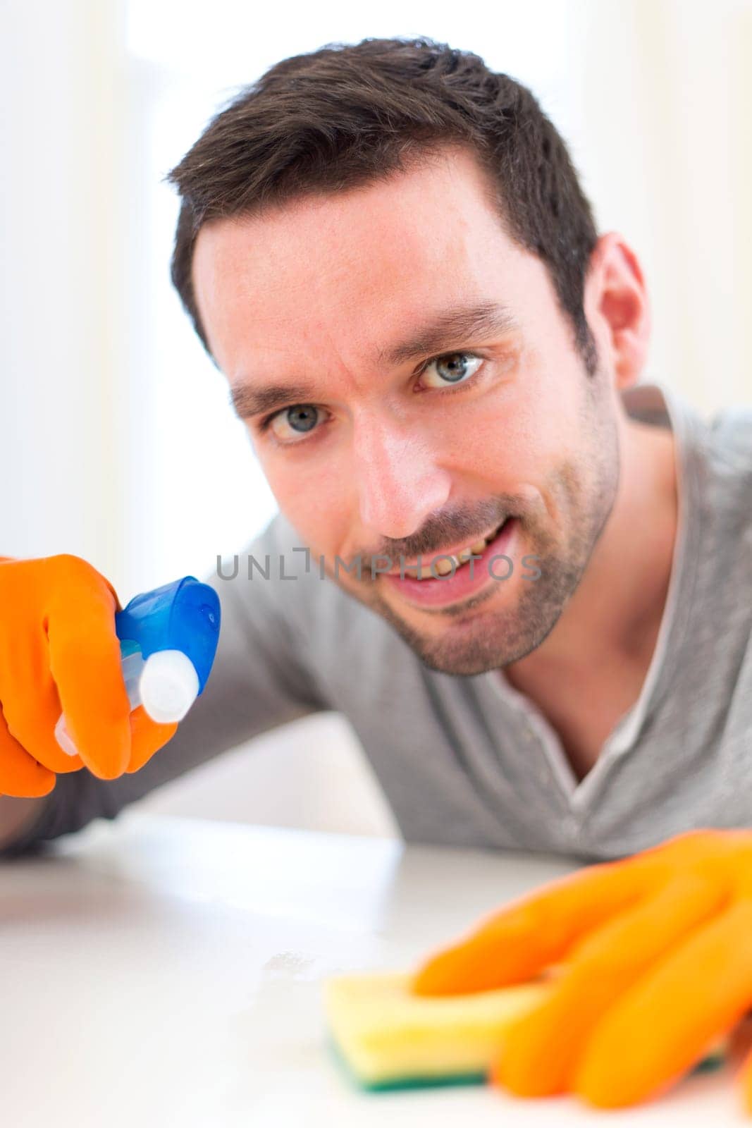 View of a Young attractive man cleaning his flat