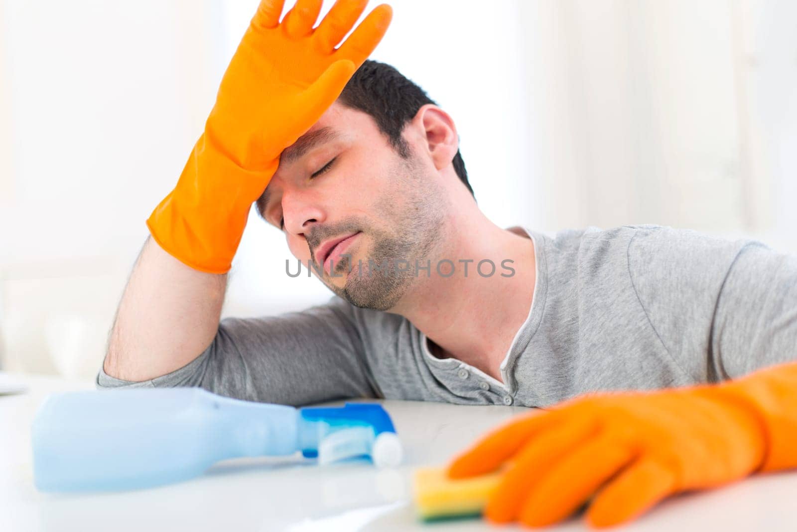 View of a Young attractive man cleaning his flat