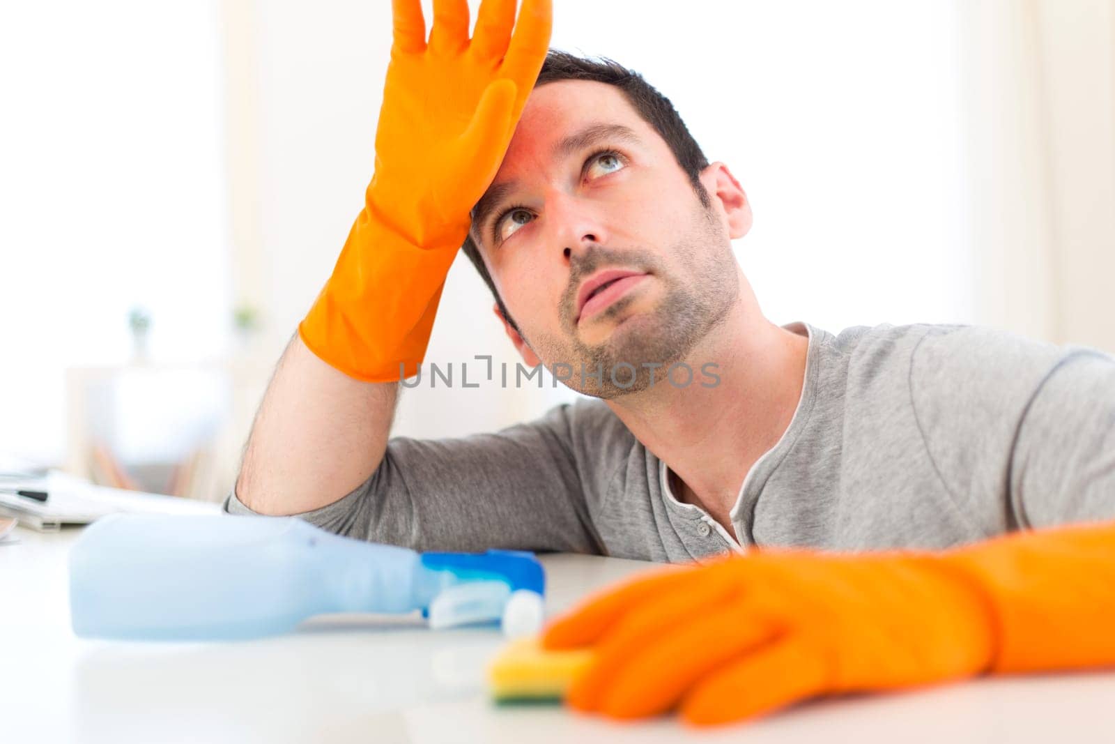 View of a Young attractive man cleaning his flat
