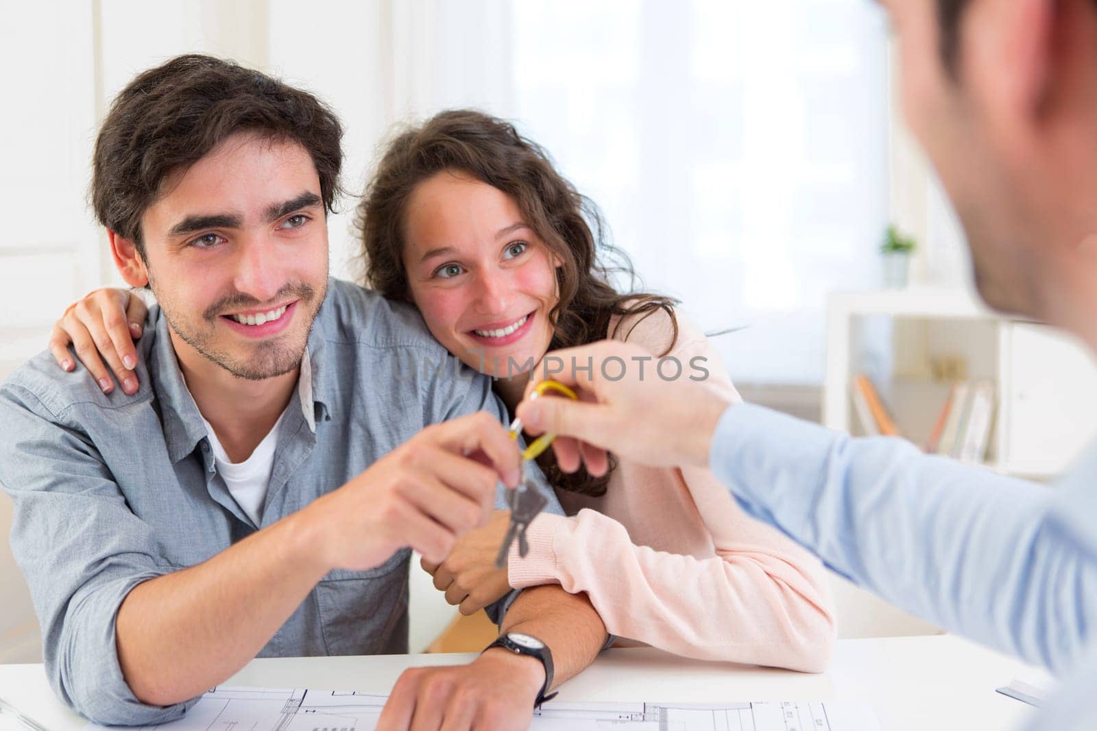 View of a Real estate handing over keys to couple