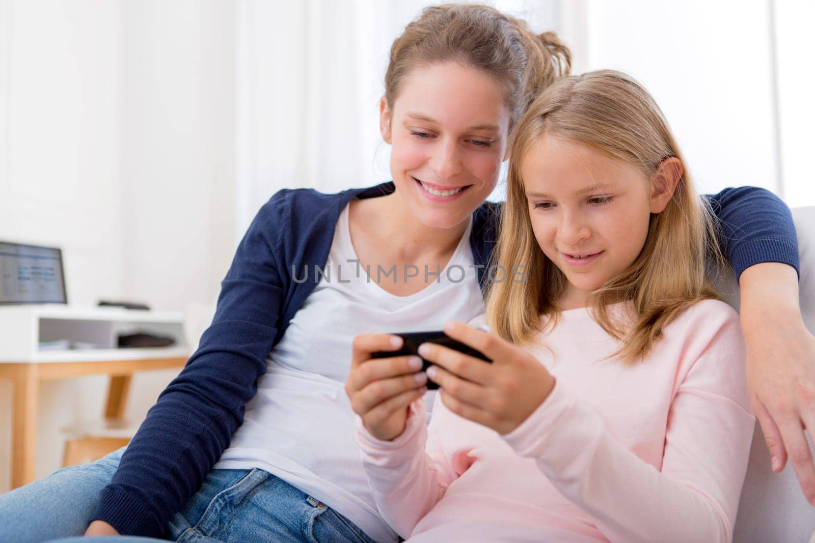 View of a Attractive woman and little sister using mobile