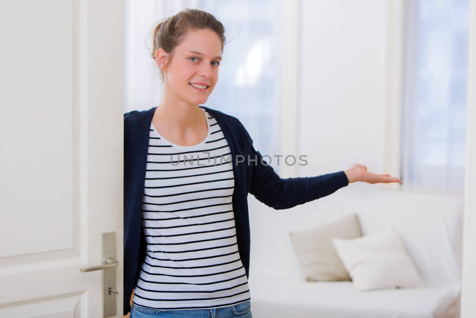 View of a Young attractive woman welcoming you in his house