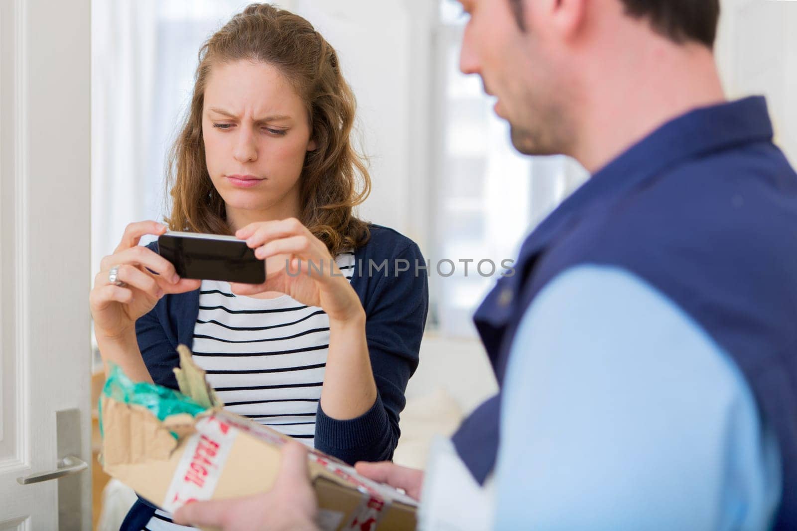 View of a Woman taking picture of her damaged parcel