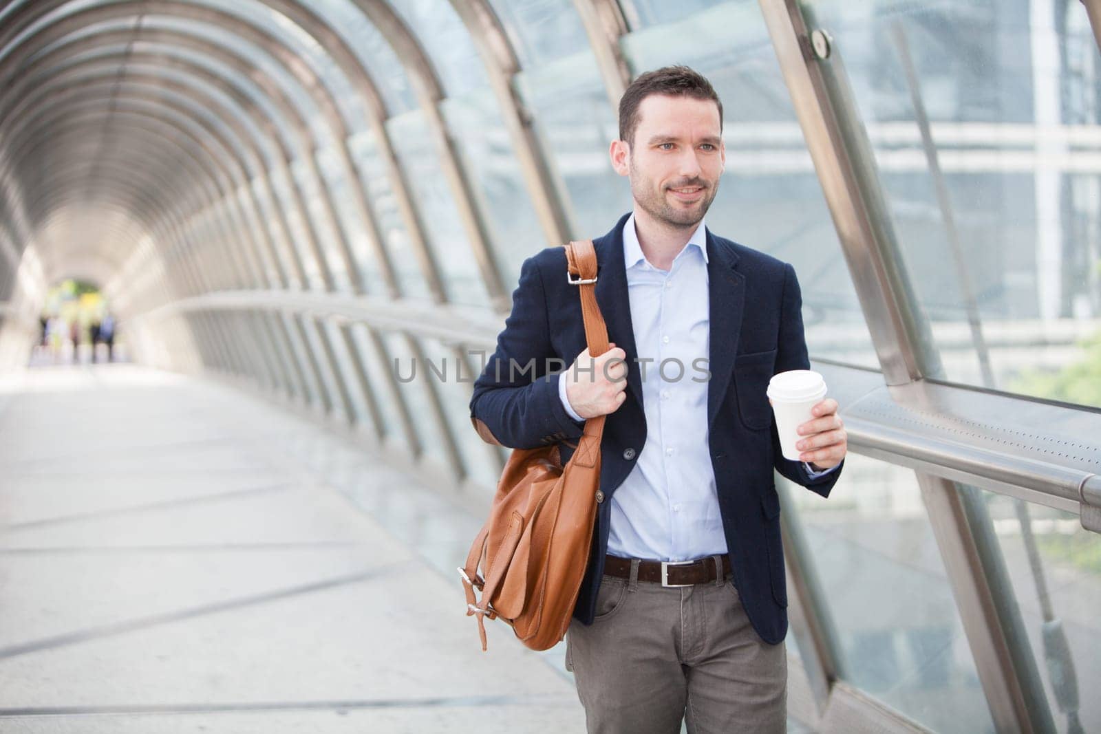 View of a Young attractive man drinking coffee on his way