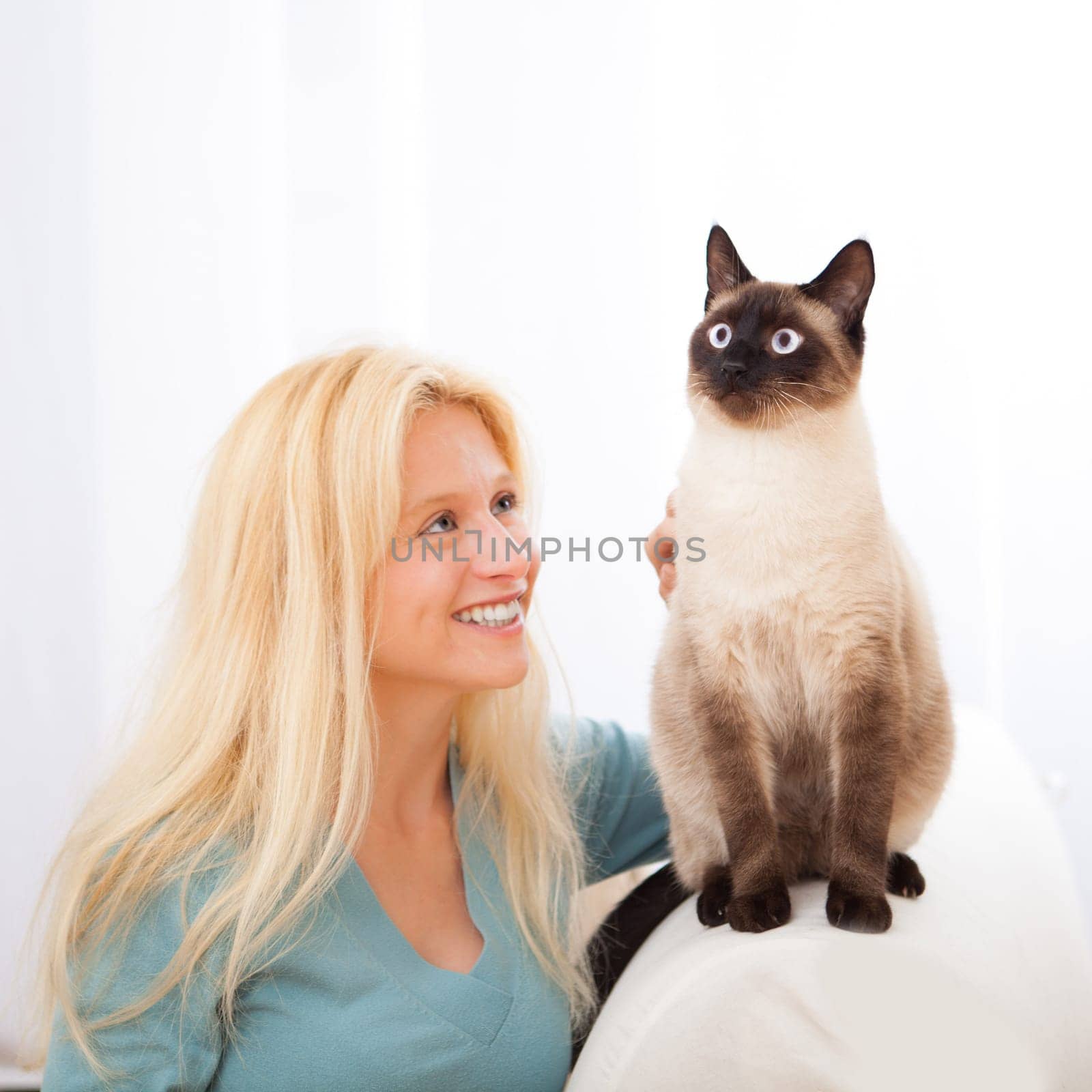 View of an Attractive blonde woman having good times with cat