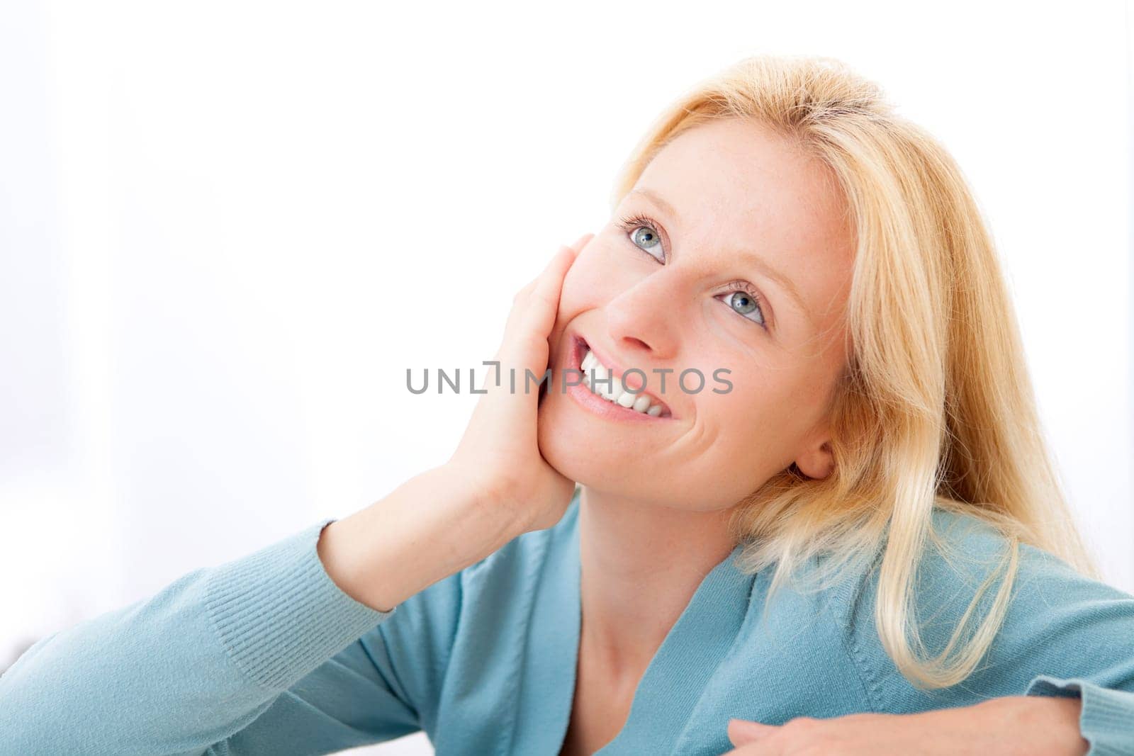 View of an Attractive pensive blonde woman in a sofa