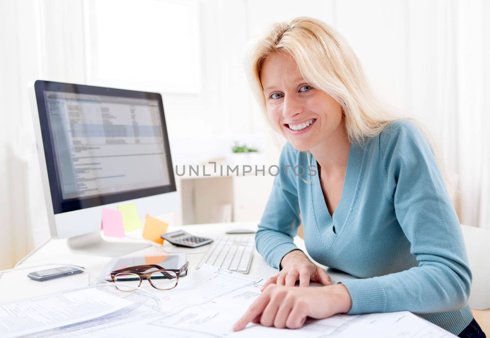 View of a Blonde architect watching blueprint at the office