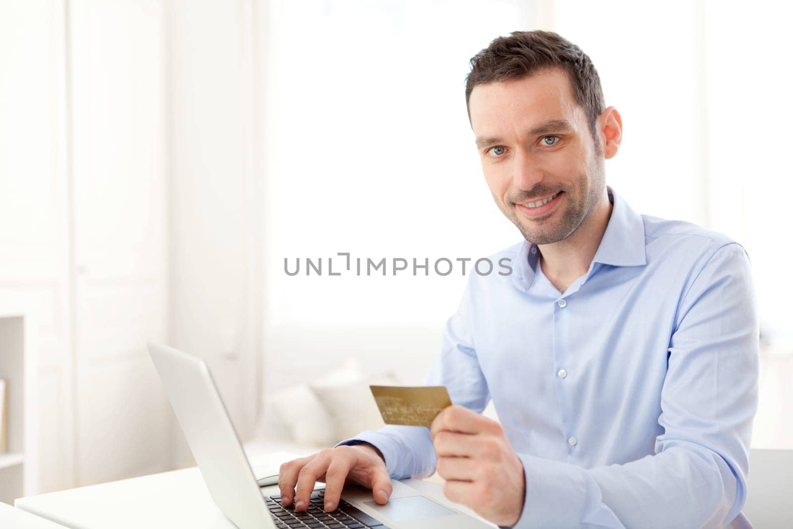 View of a Young business man paying online with credit card