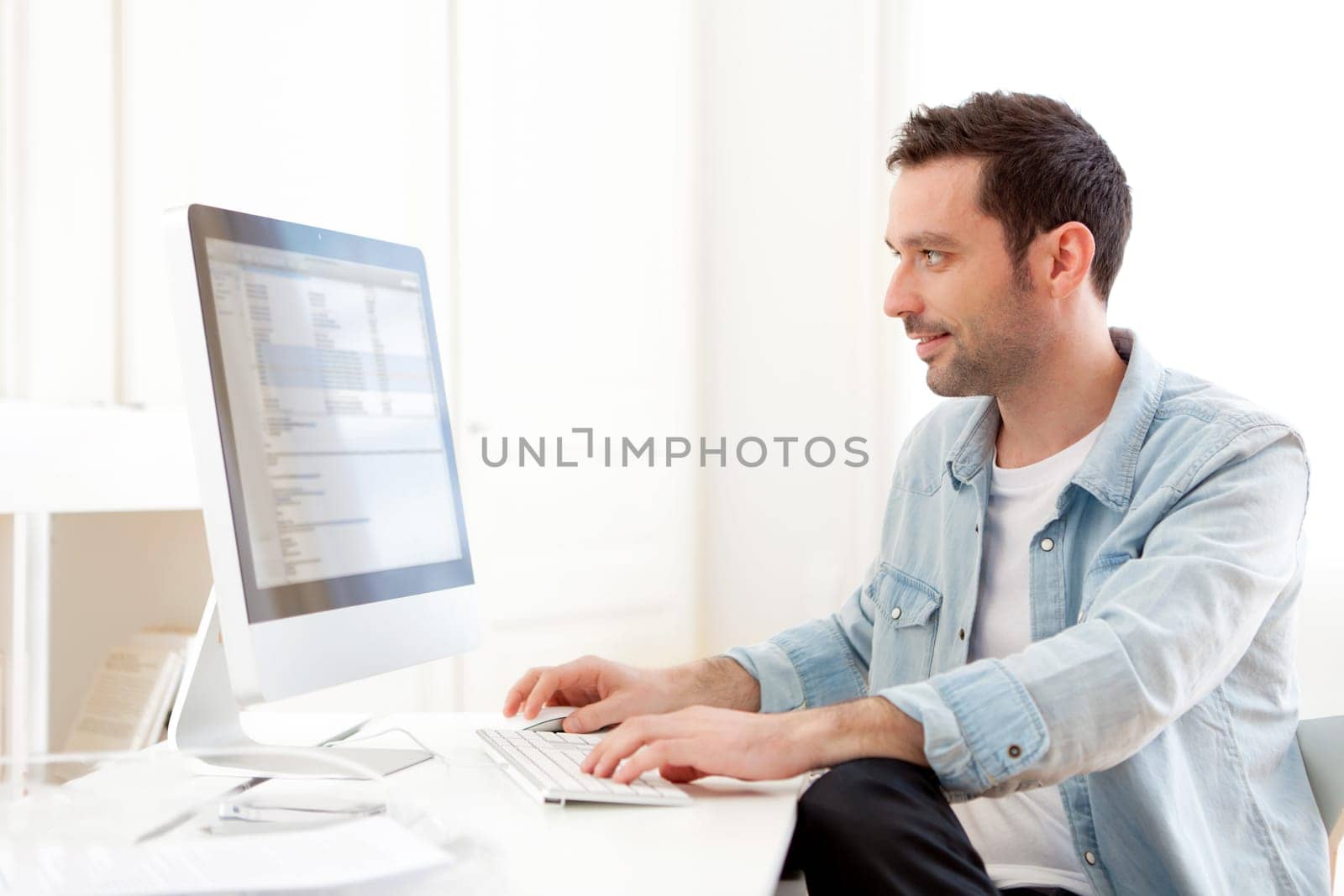 View of a young relaxed man using computer