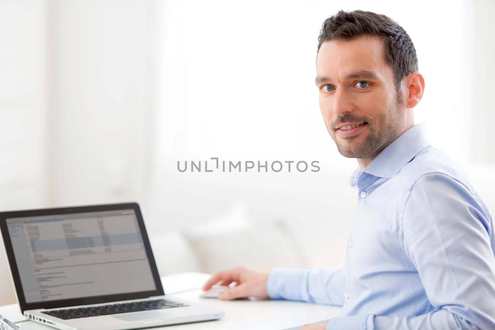 View of a Young business man working at home on his laptop
