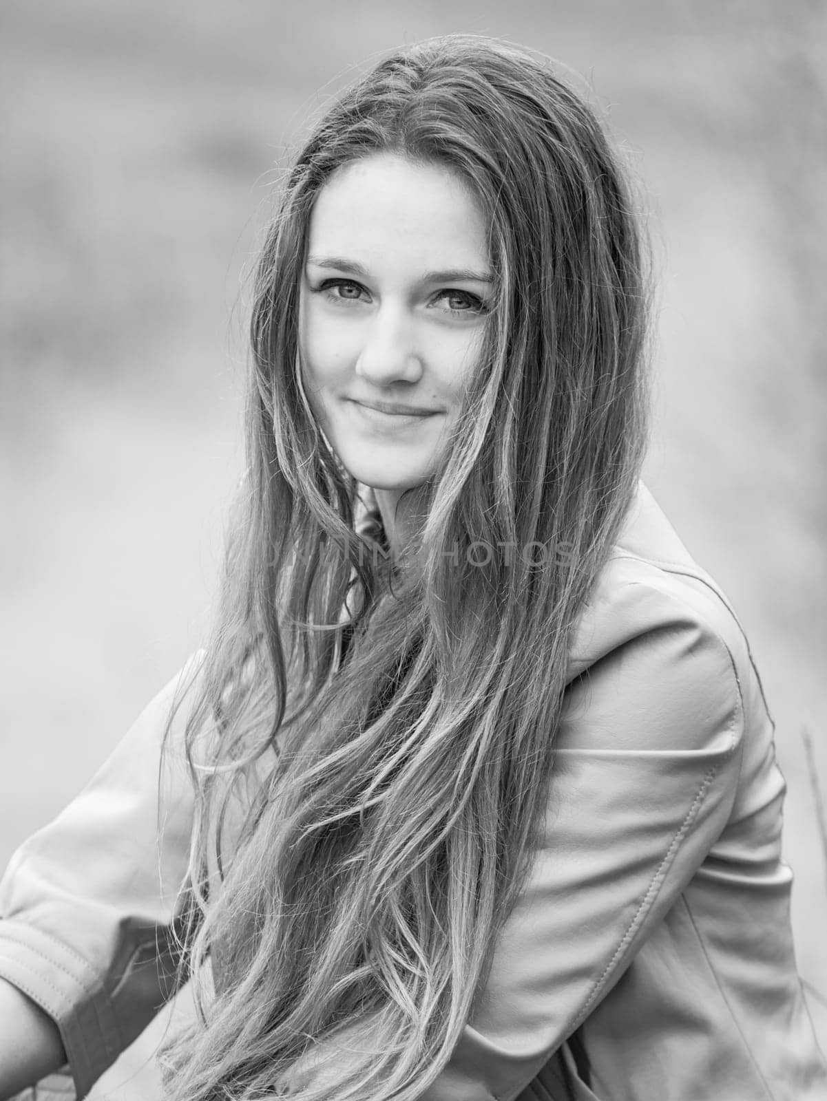 Outdoor portrait of beautiful teenage girl in spring in black and white.
