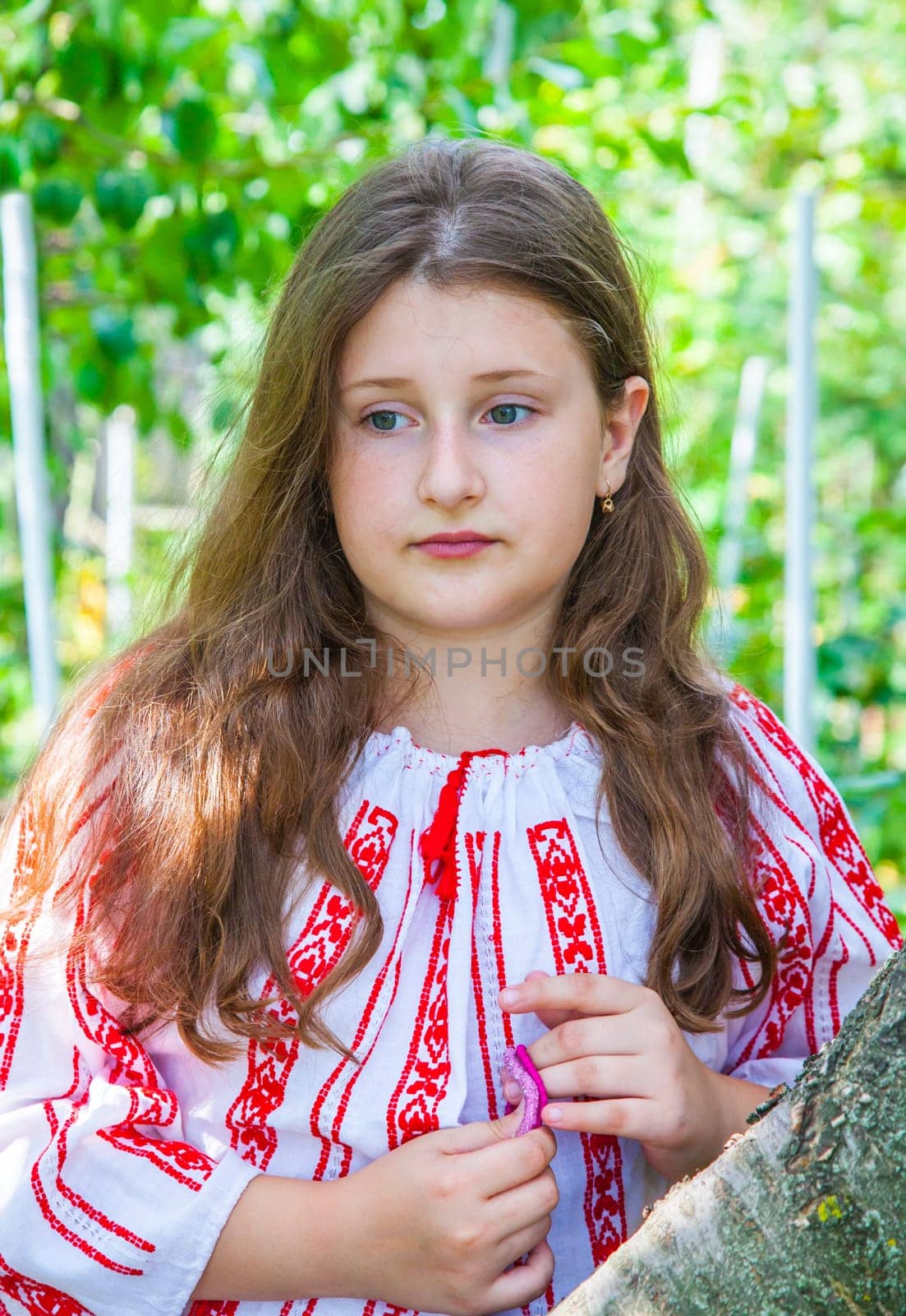 Portrait of a 10 year old girl wearing a Romanian traditional blouse.