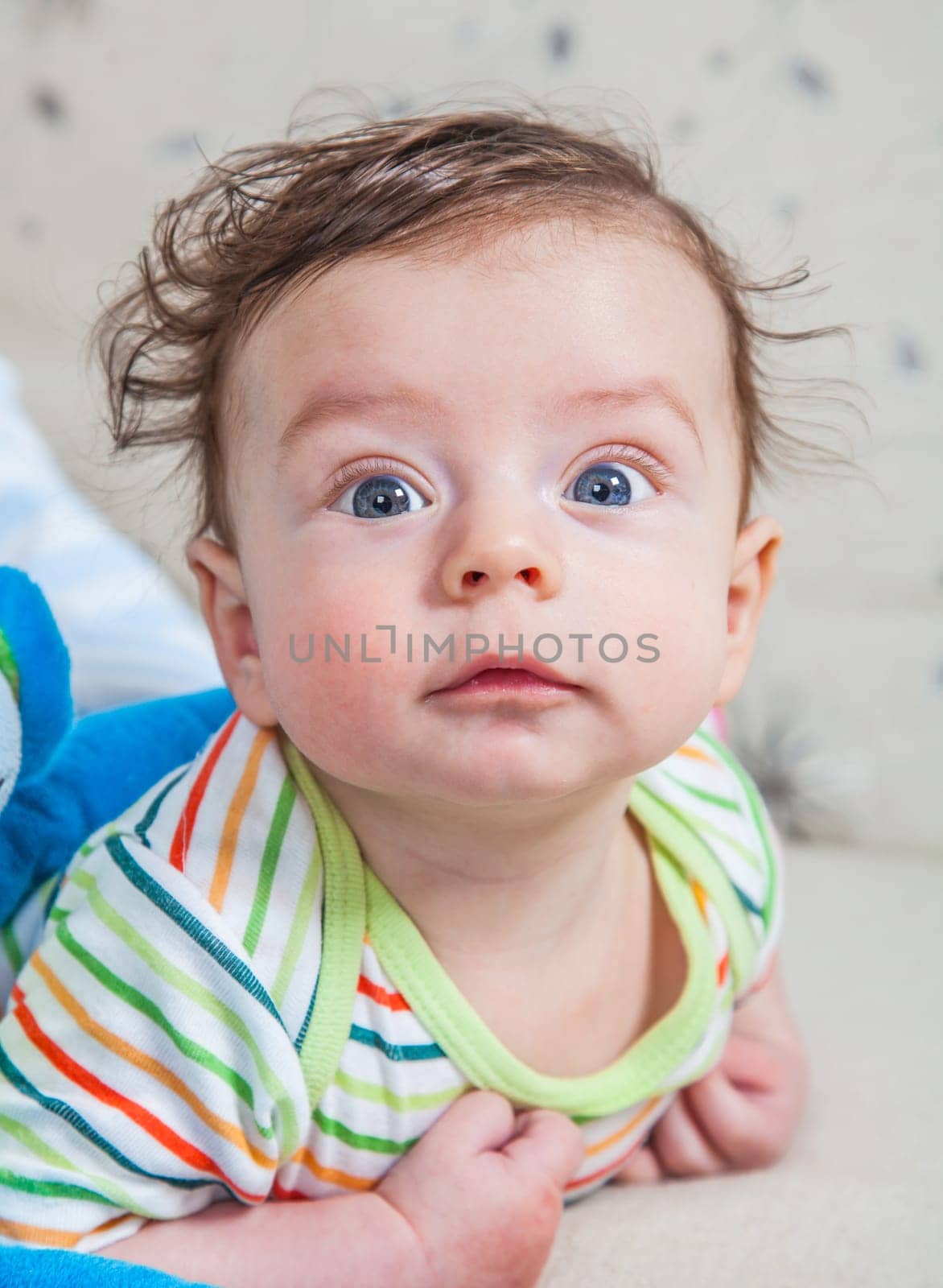Portrait of an adorable smiling baby playing with a monkey toy.