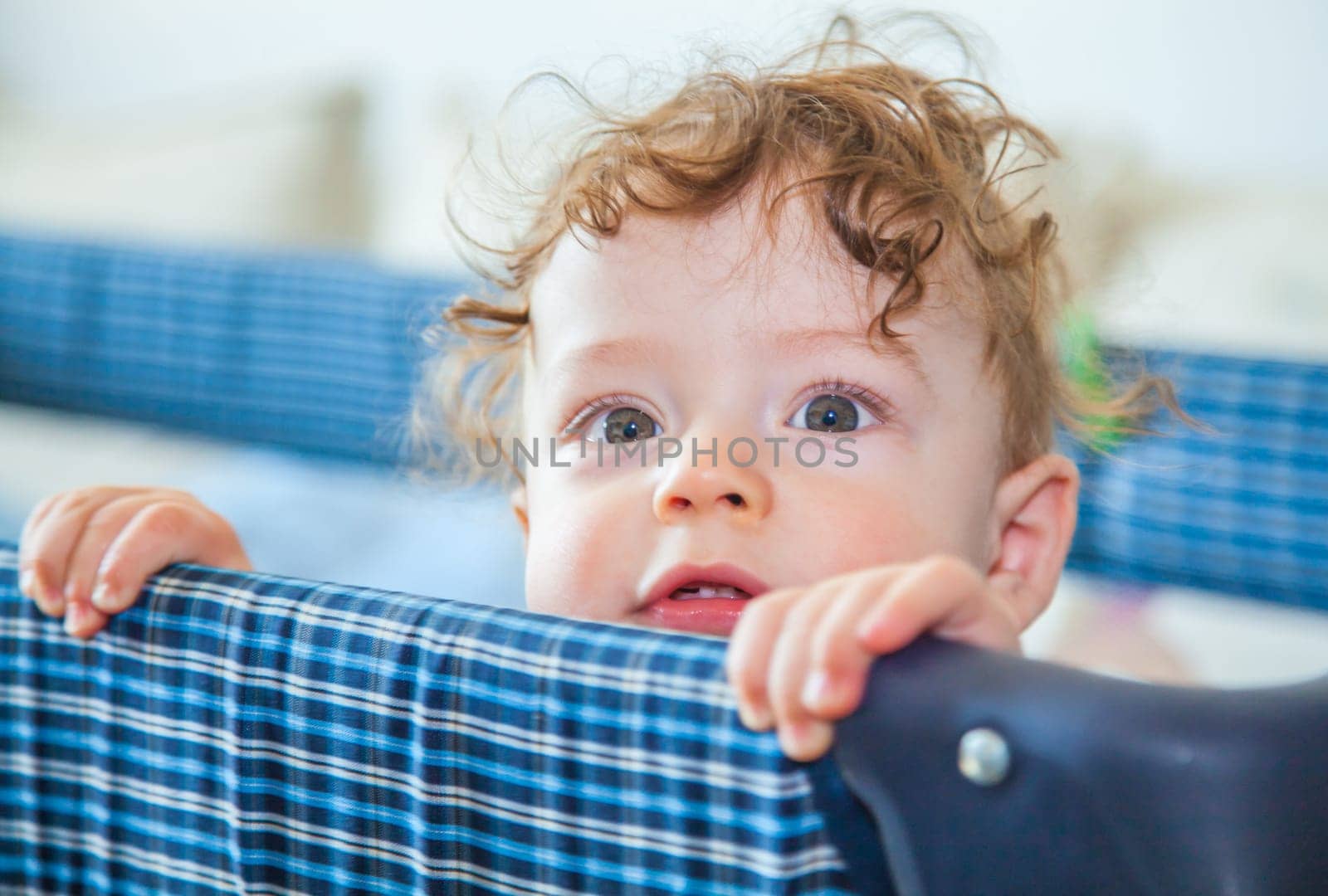 Portrait of a 9 months old baby boy peeking from his