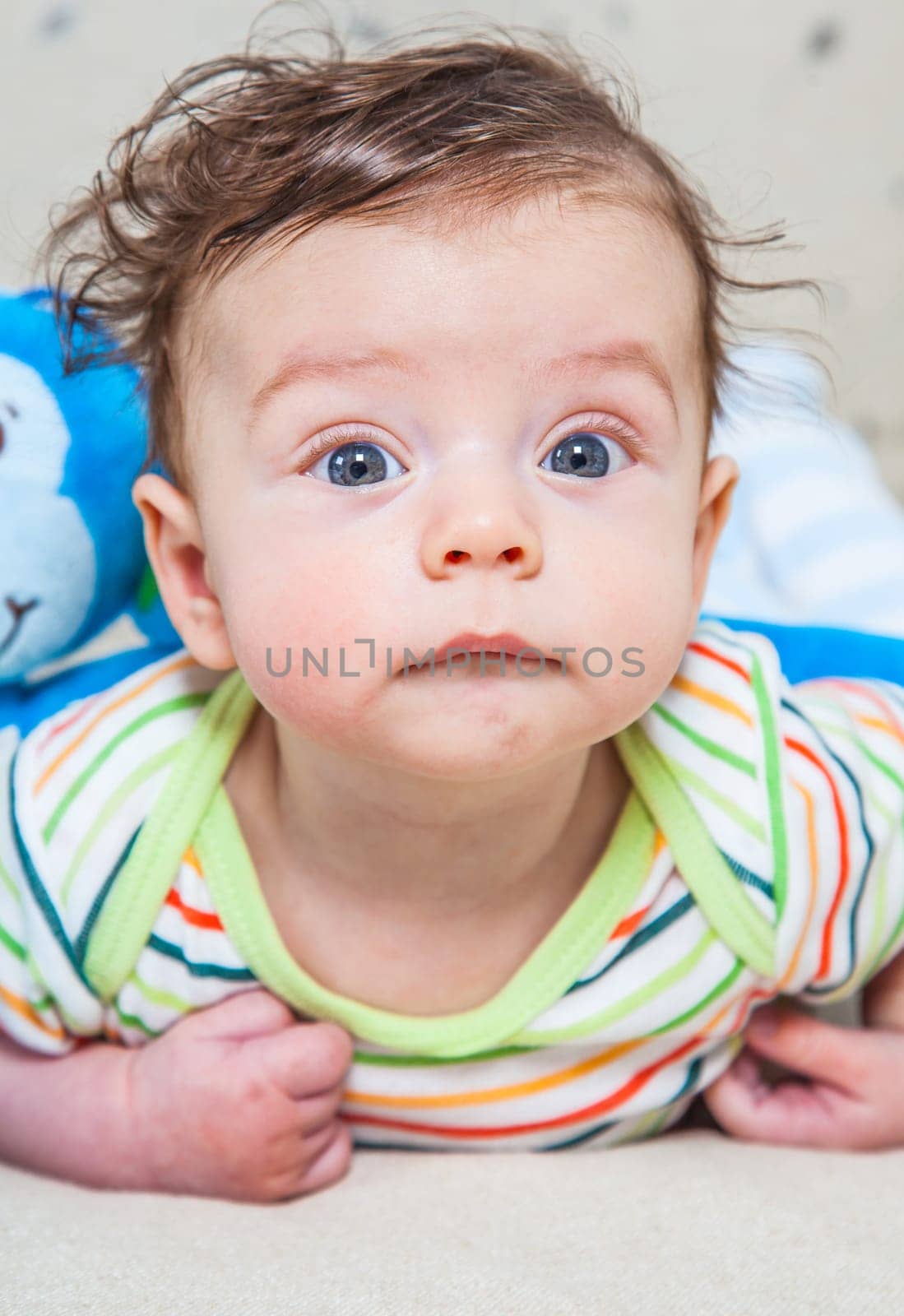 Portrait of an adorable smiling baby playing with a monkey toy.