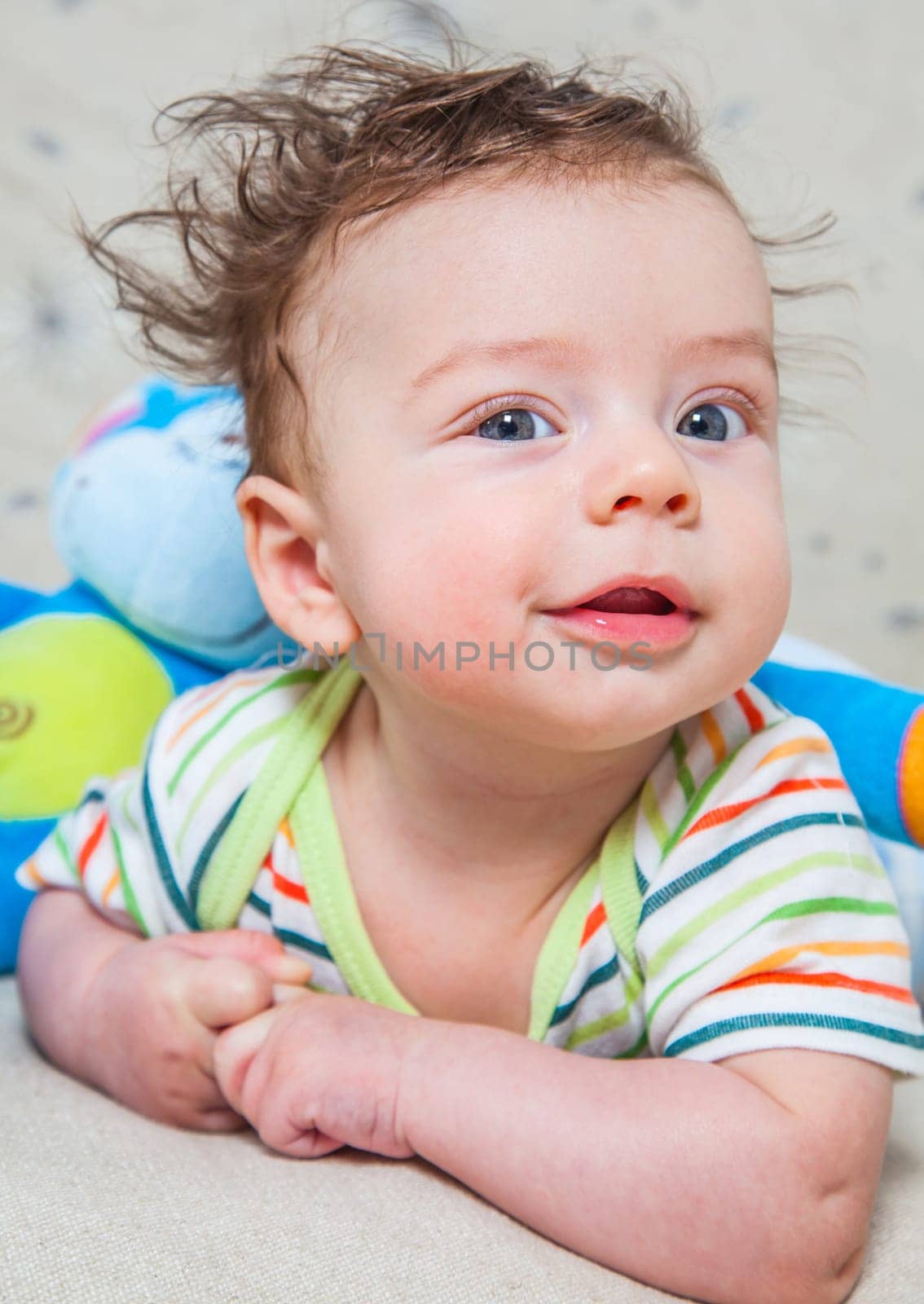 Portrait of an adorable smiling baby playing with a monkey toy.