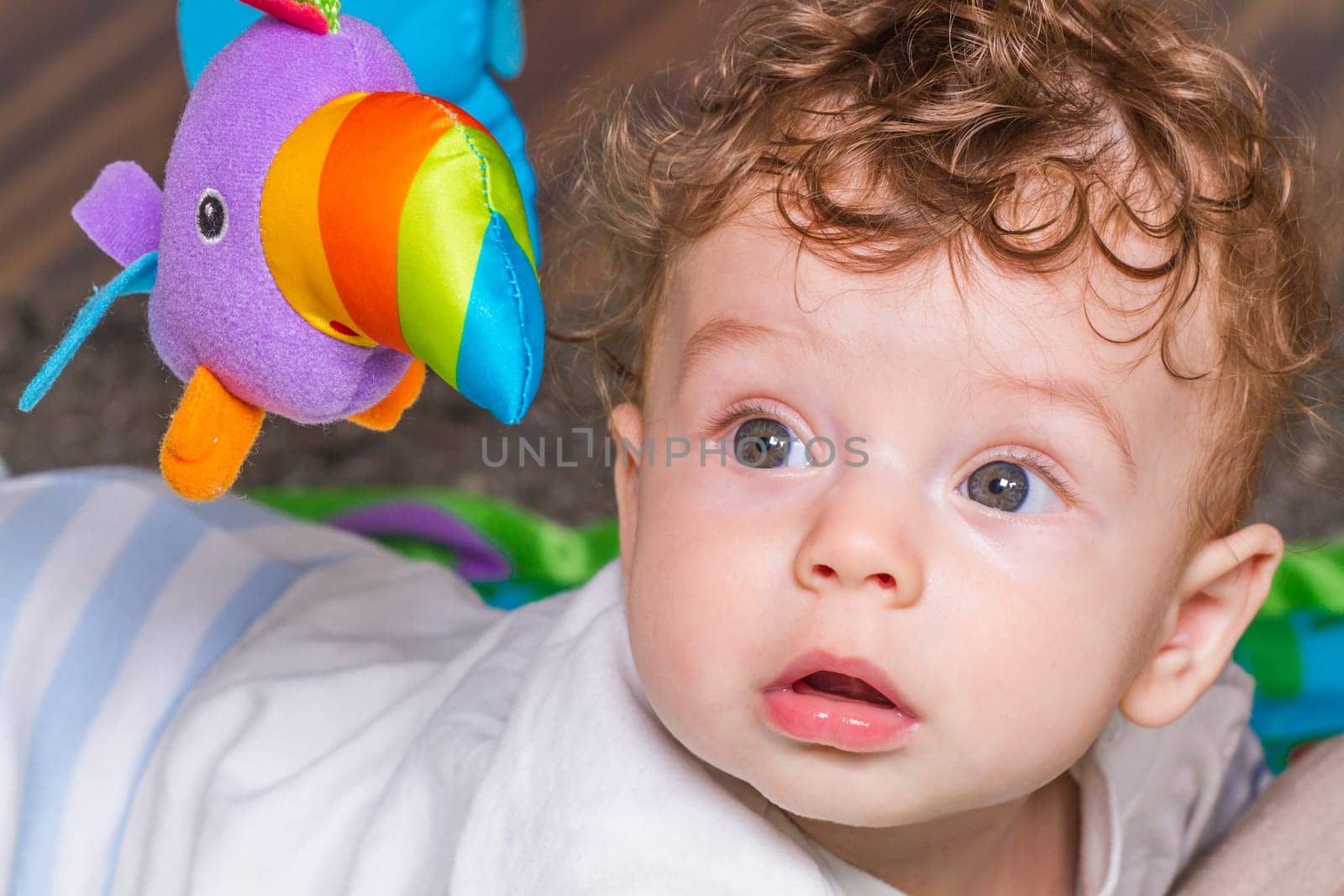 Portrait of a 7 months old baby boy at home with his toys.
