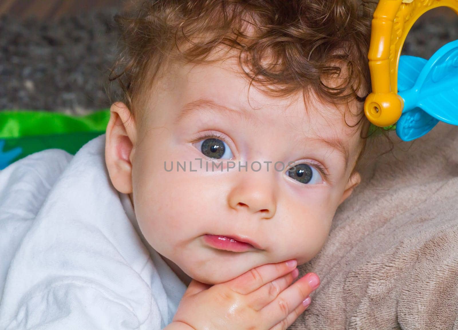 Portrait of a 7 months old baby boy at home with his toys.