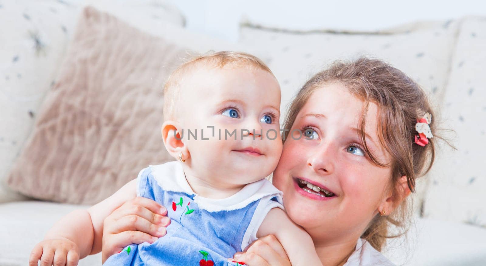 Big sister holding her 1 year old baby sister.
