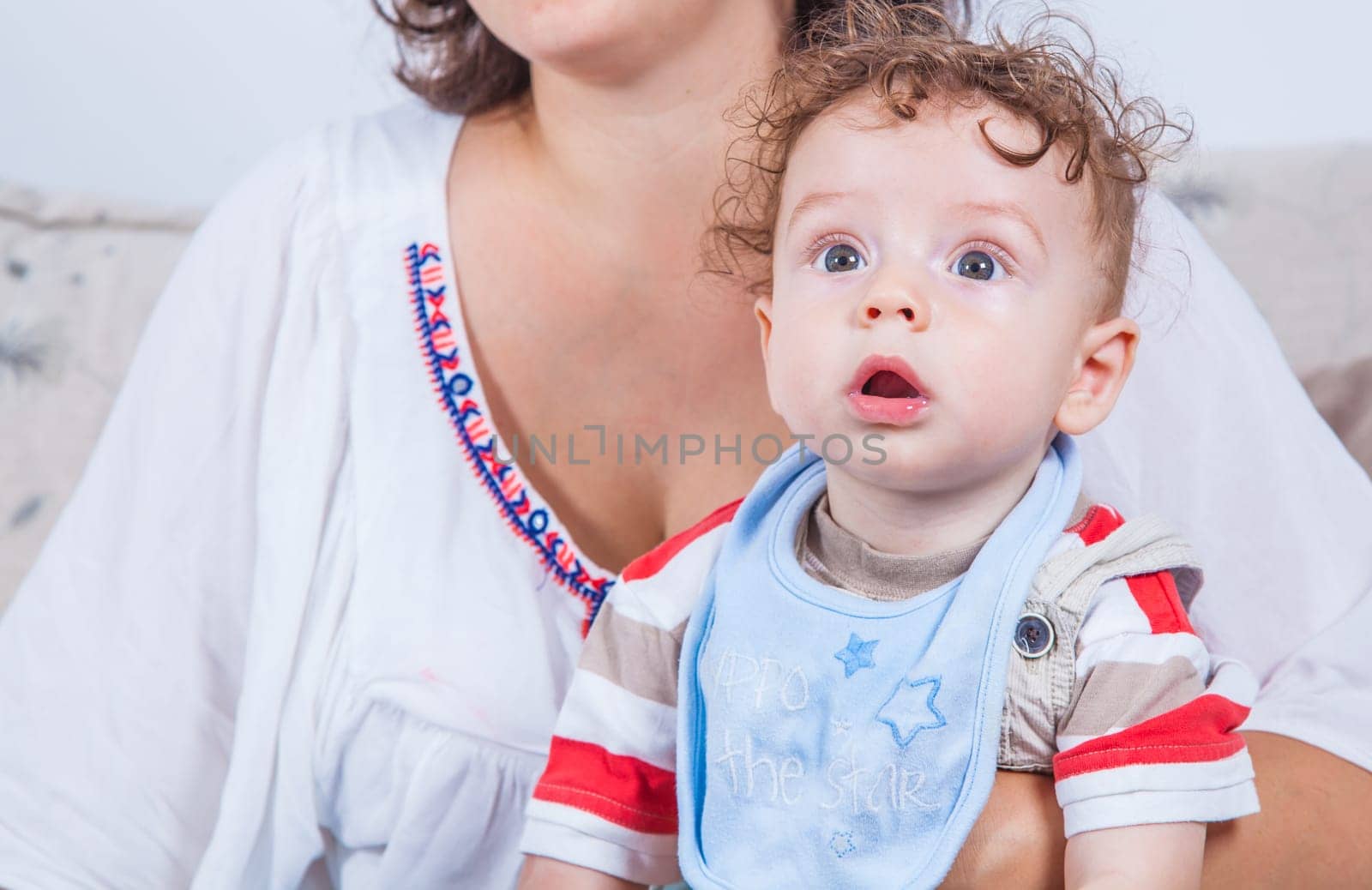 Portrait of 7 months old baby boy in woman's arms.