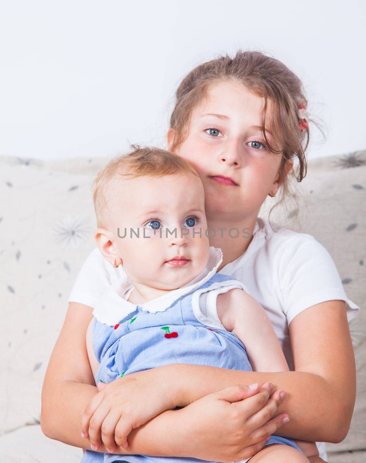 Big sister holding her 1 year old baby sister.