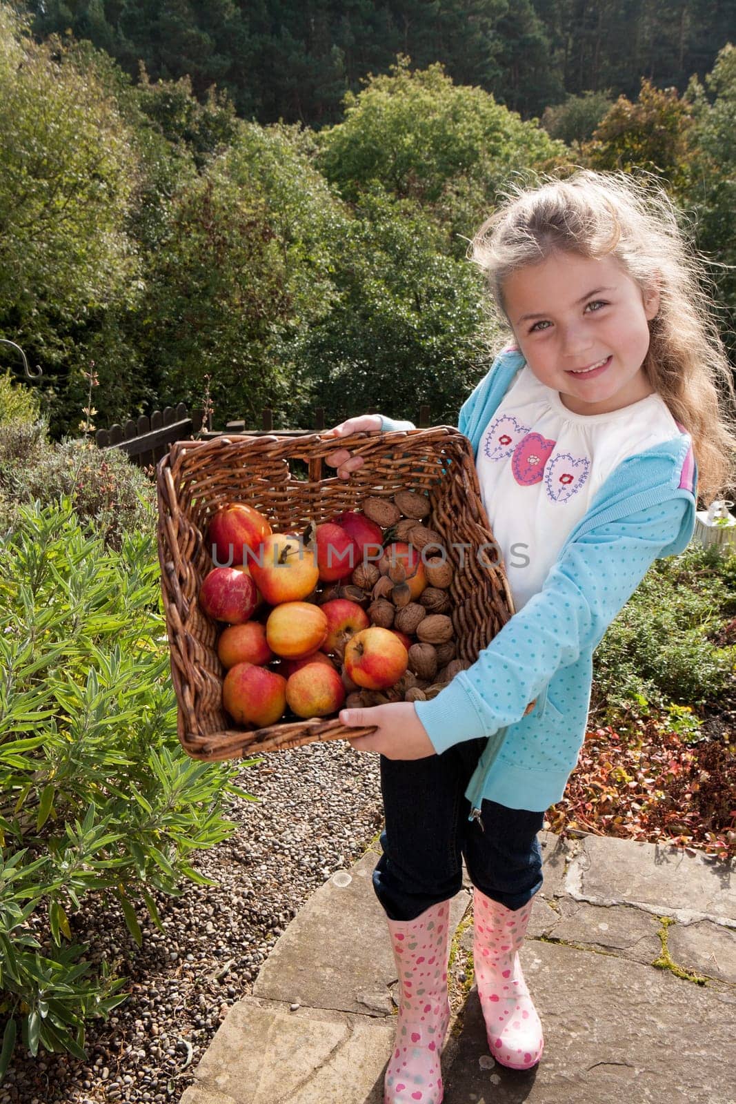 Young girl posing with a basket of hand-picked fruit