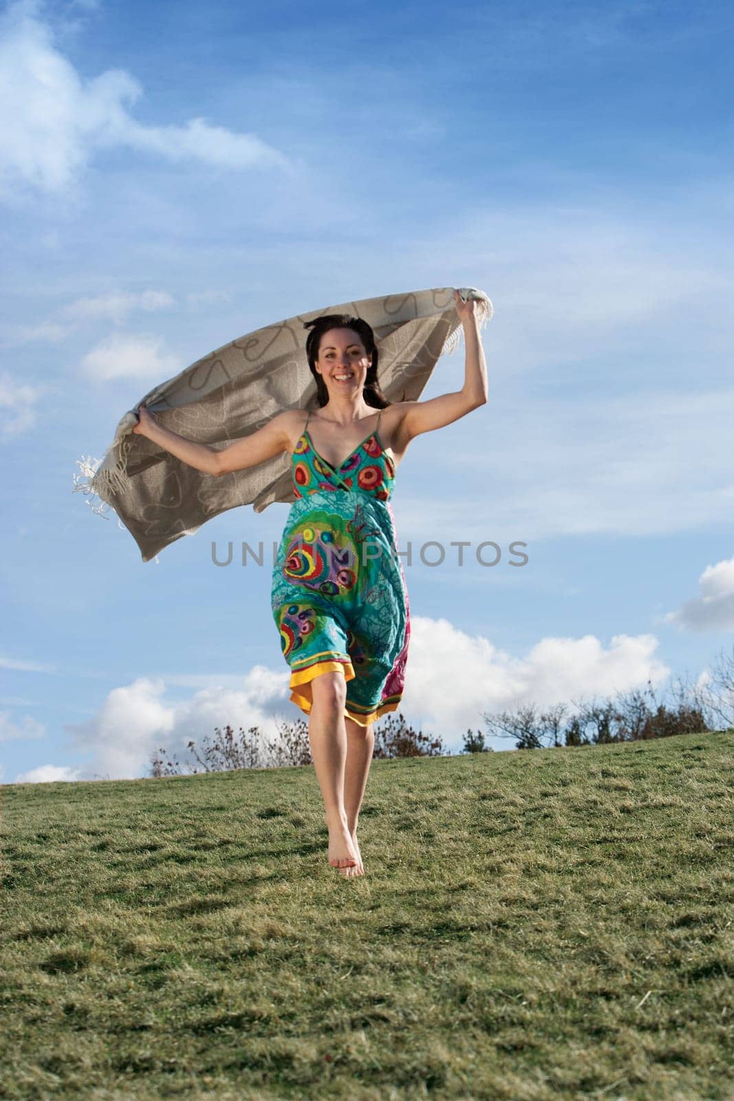 young woman running with a blanket behind her