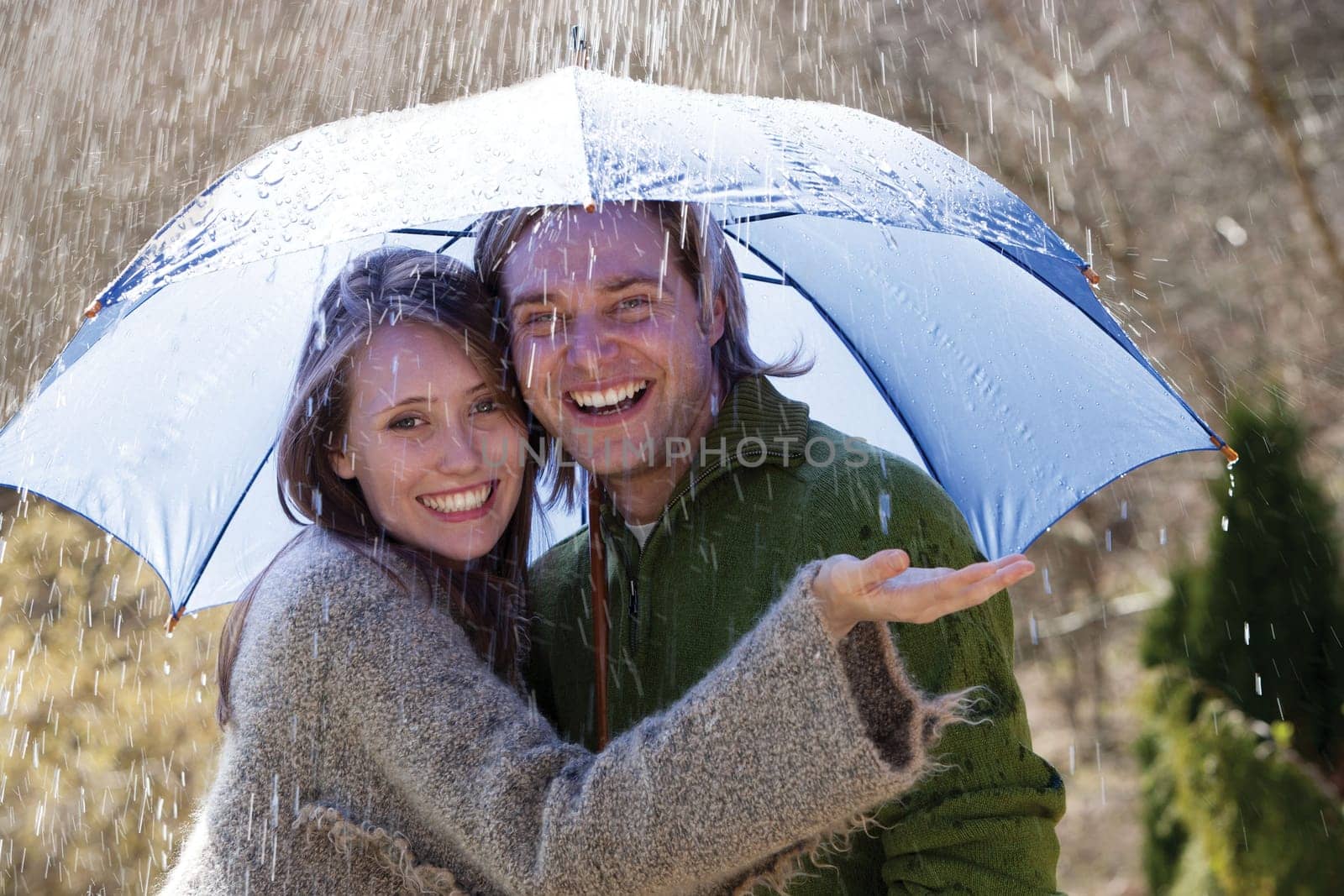Young couple enjoying the rain under an umbrella