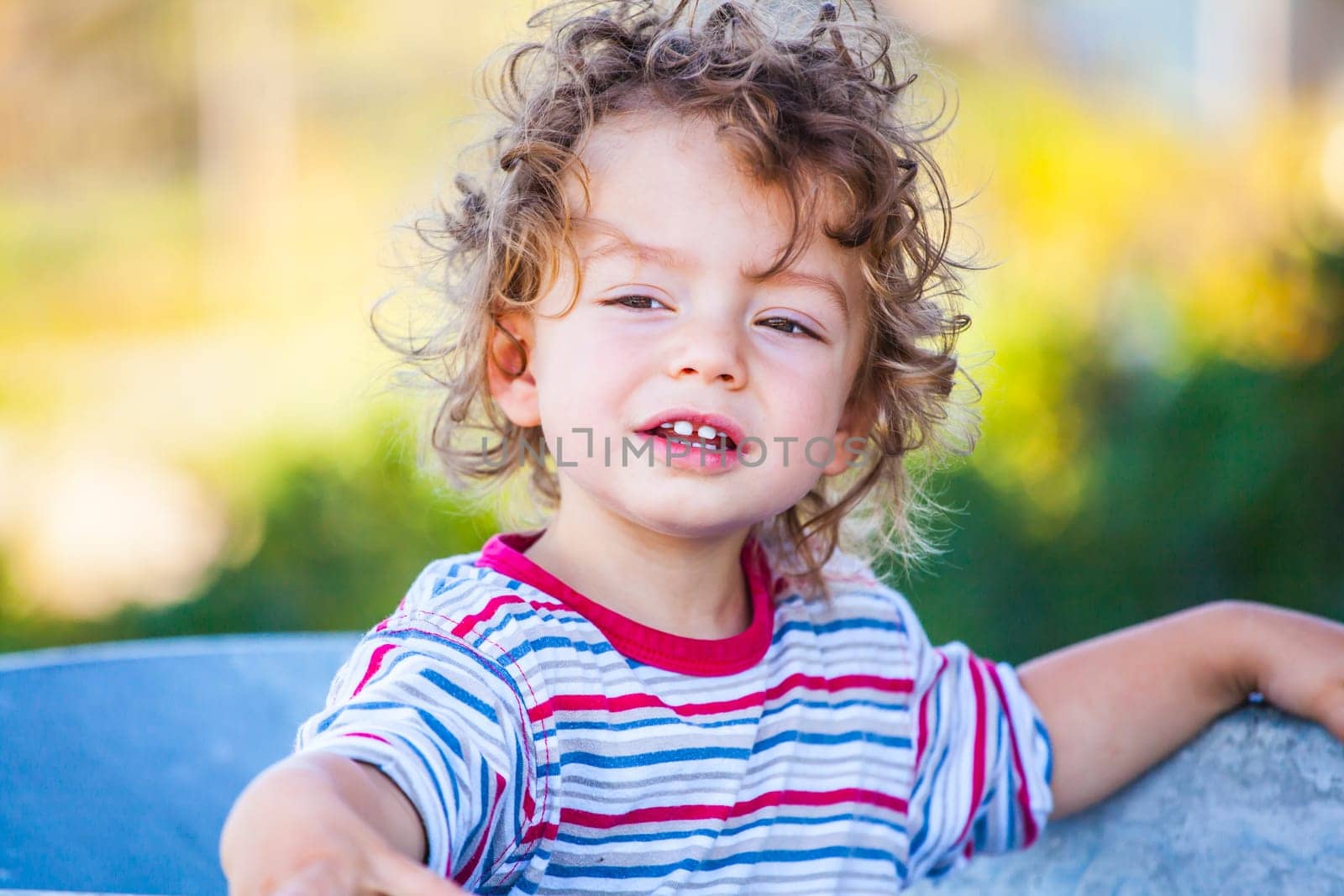 Portrait of 1 year old baby boy playing with a wheel barrow.