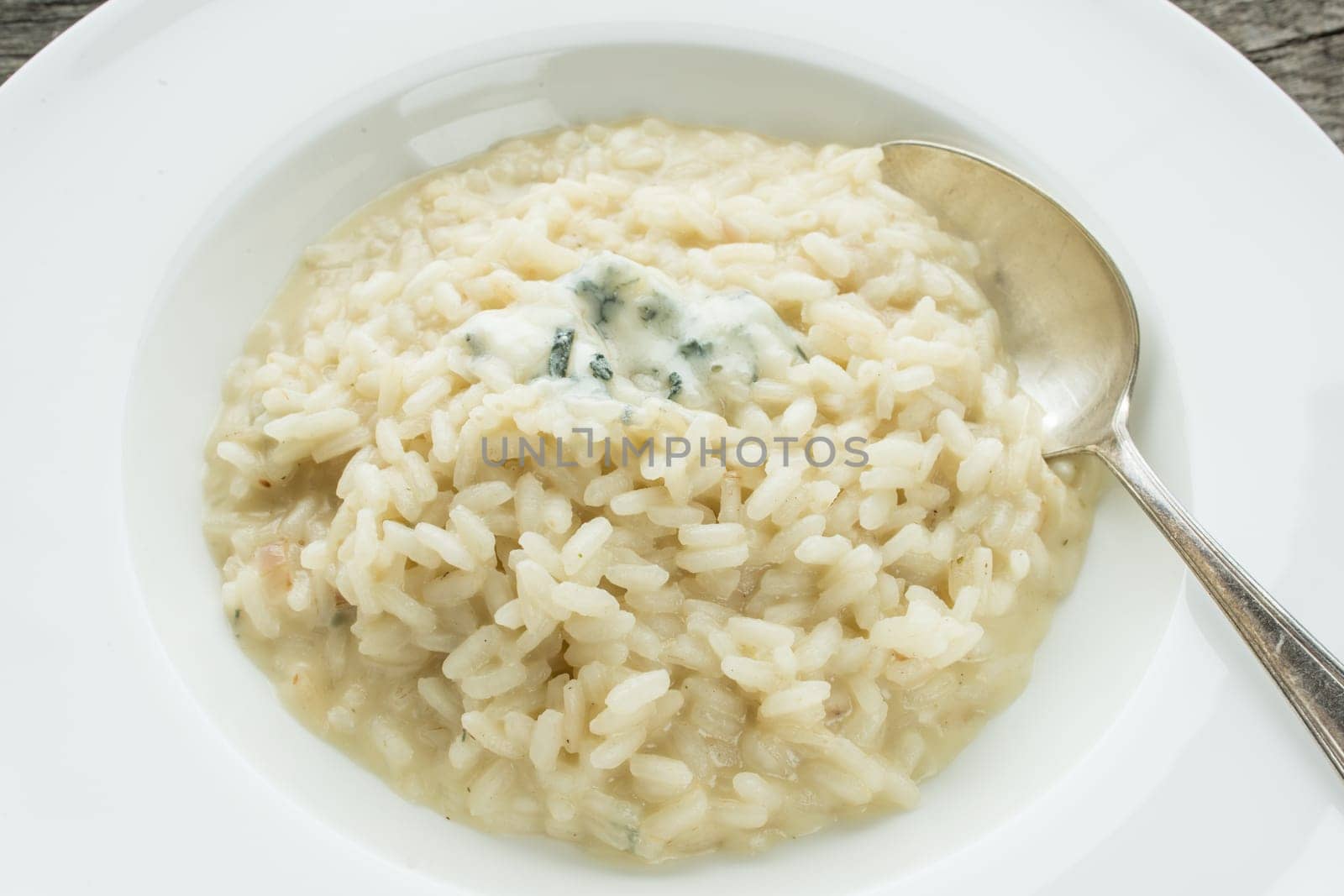 Spoon with risotto and Gorgonzola cheese
