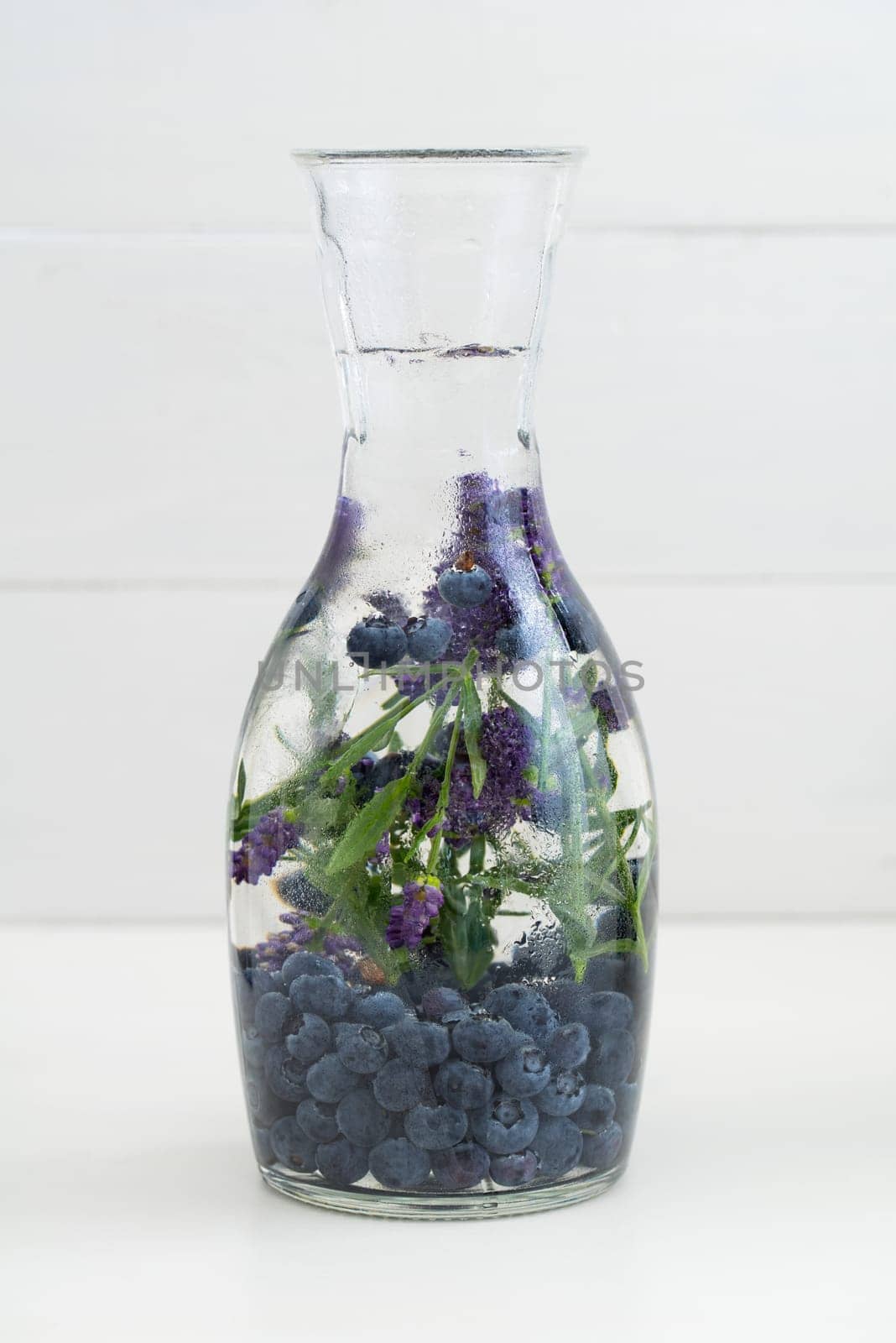 Flavoured water or infused water with blueberries and lavender in a carafe