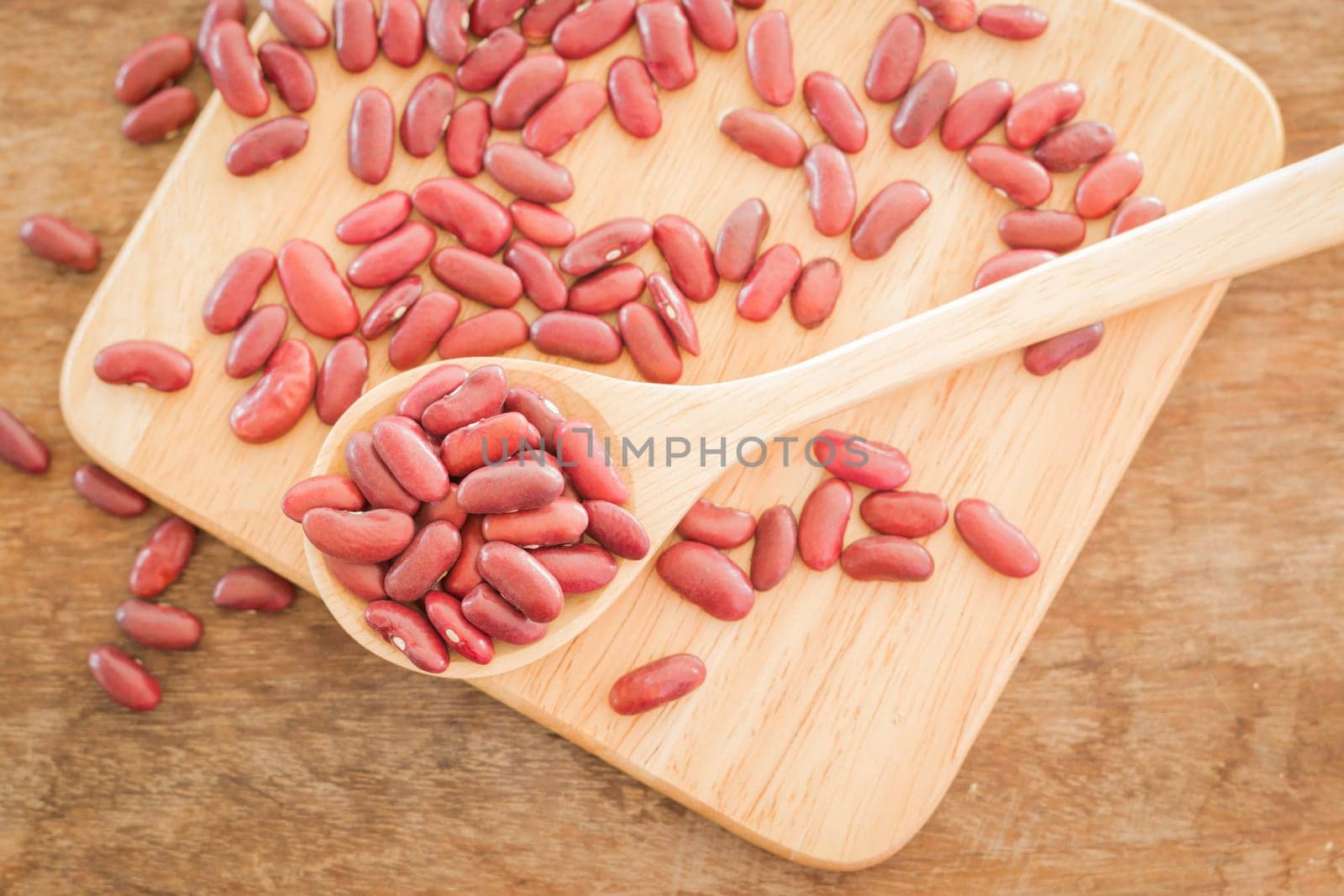 Raw red kidney bean on wooden table, stock photo