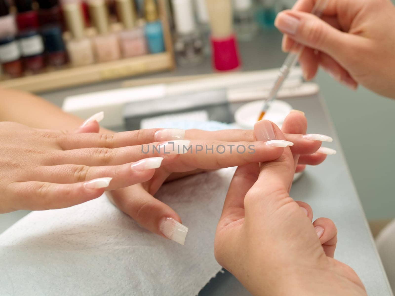 Girl fingernails being manicured.
