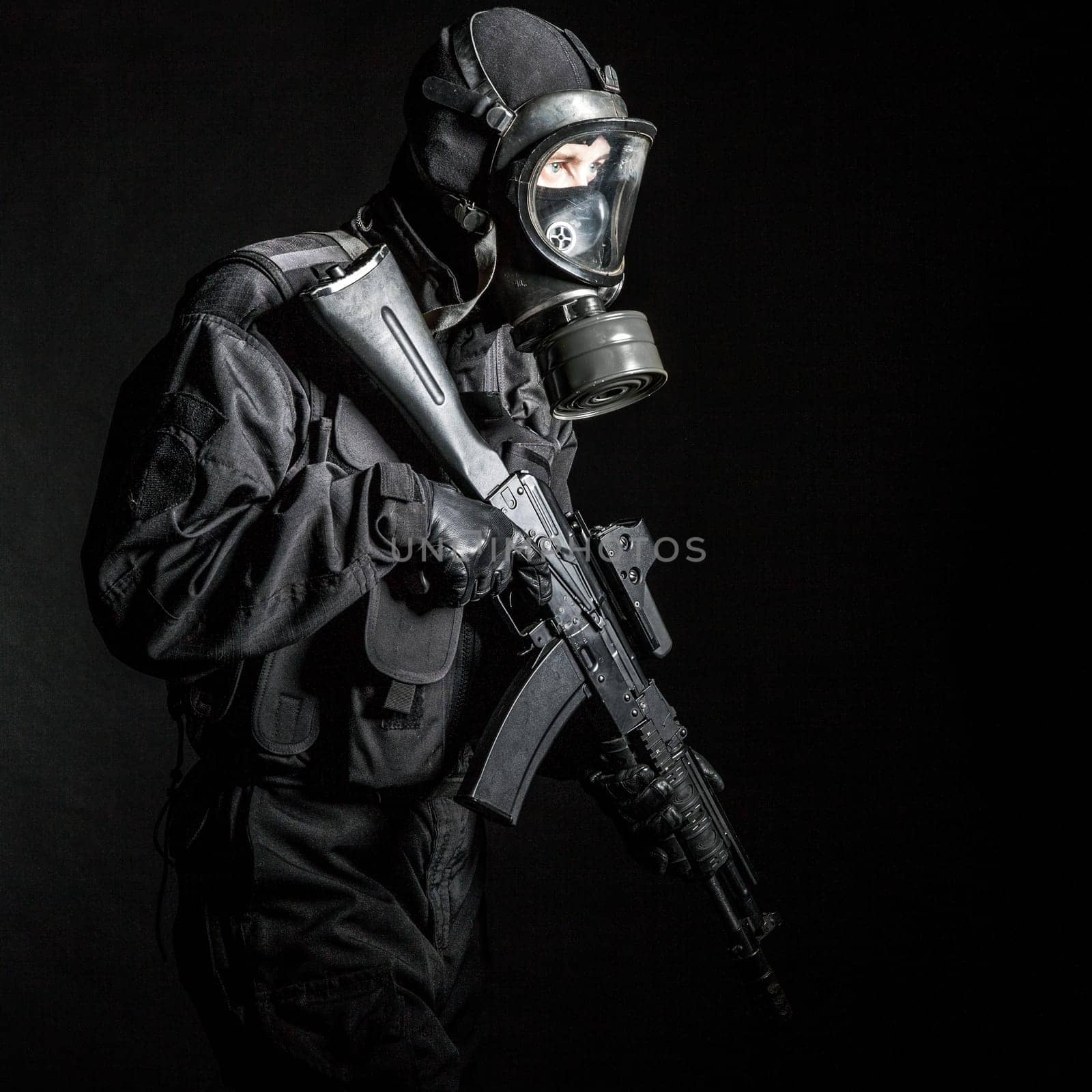 Russian special forces operator in black uniform and gas mask