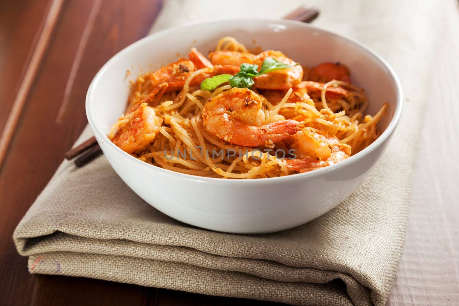Thai rice noodles with shrimps in a bowl with chopsticks