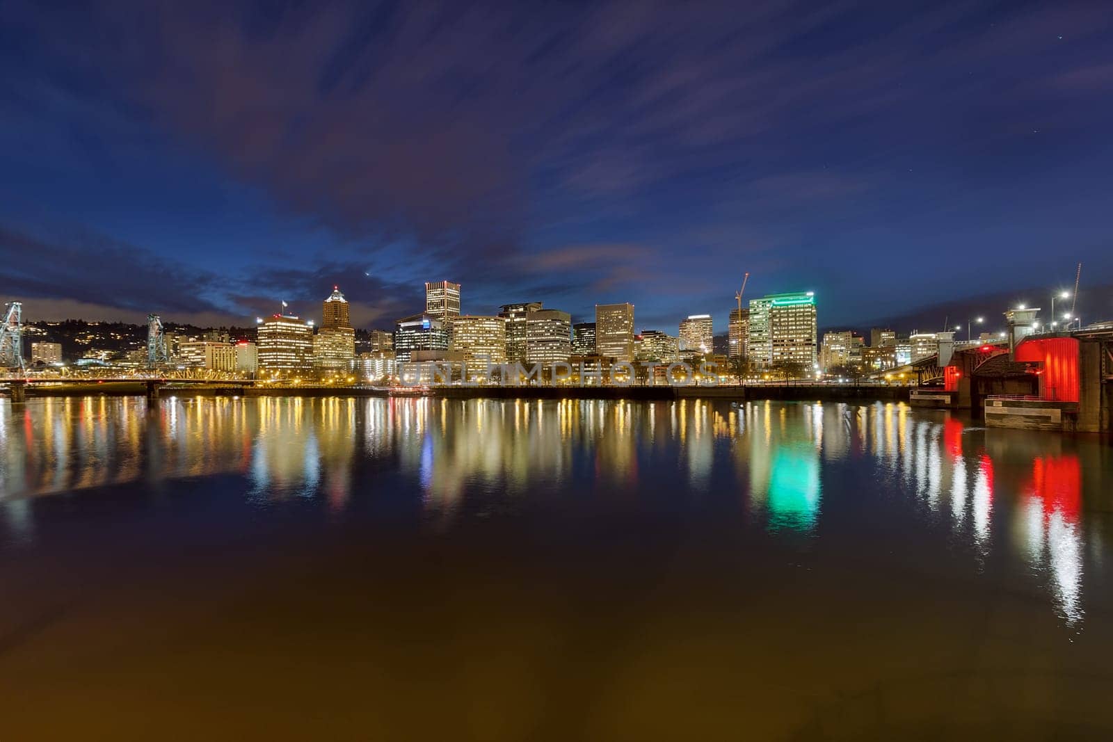 Portland Oregon downtown city skyline between Morrison Bridge and Hawthorne Bridge along Willamette River at Evening Blue Hour