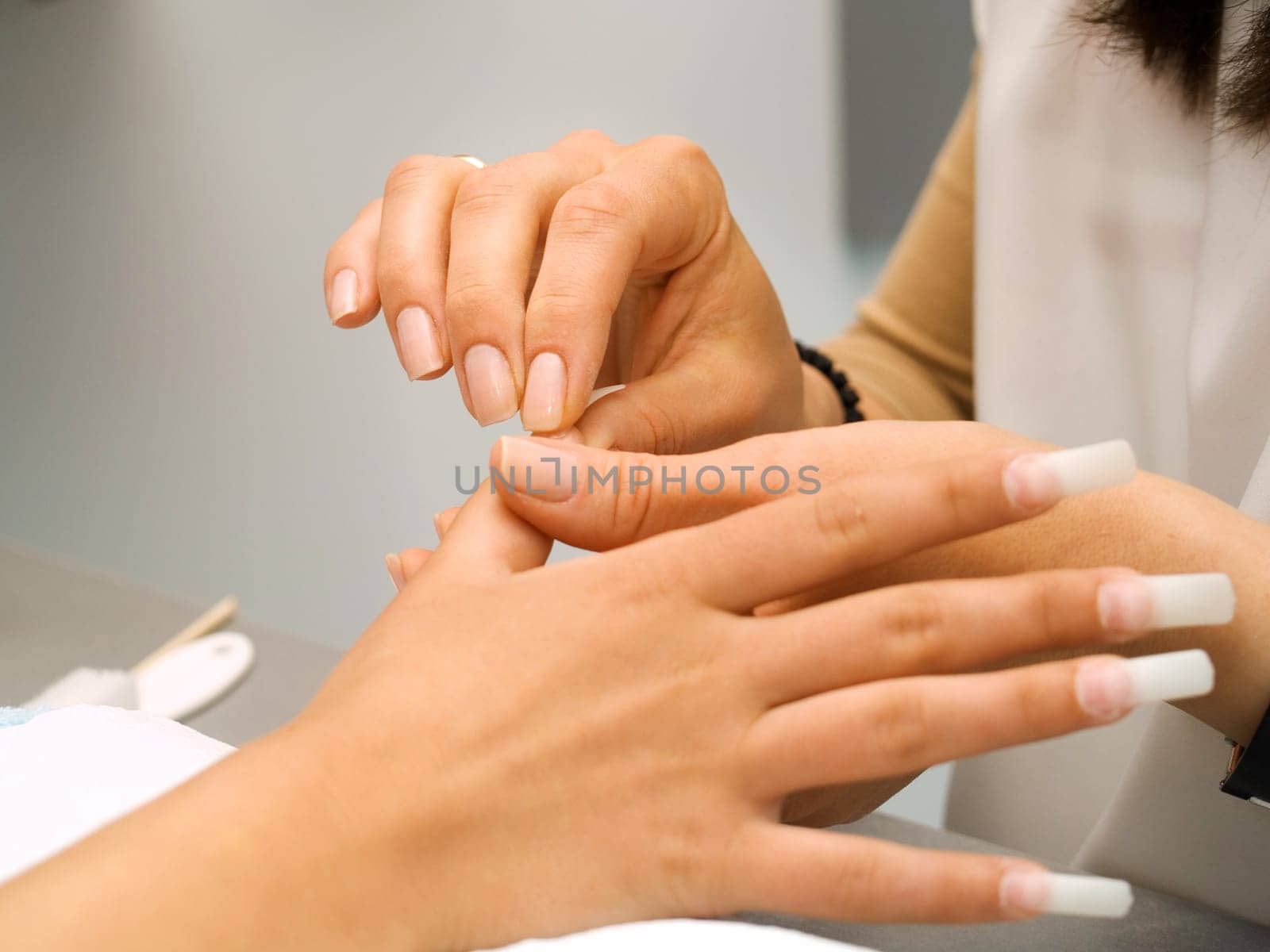 Girl fingernails being manicured.