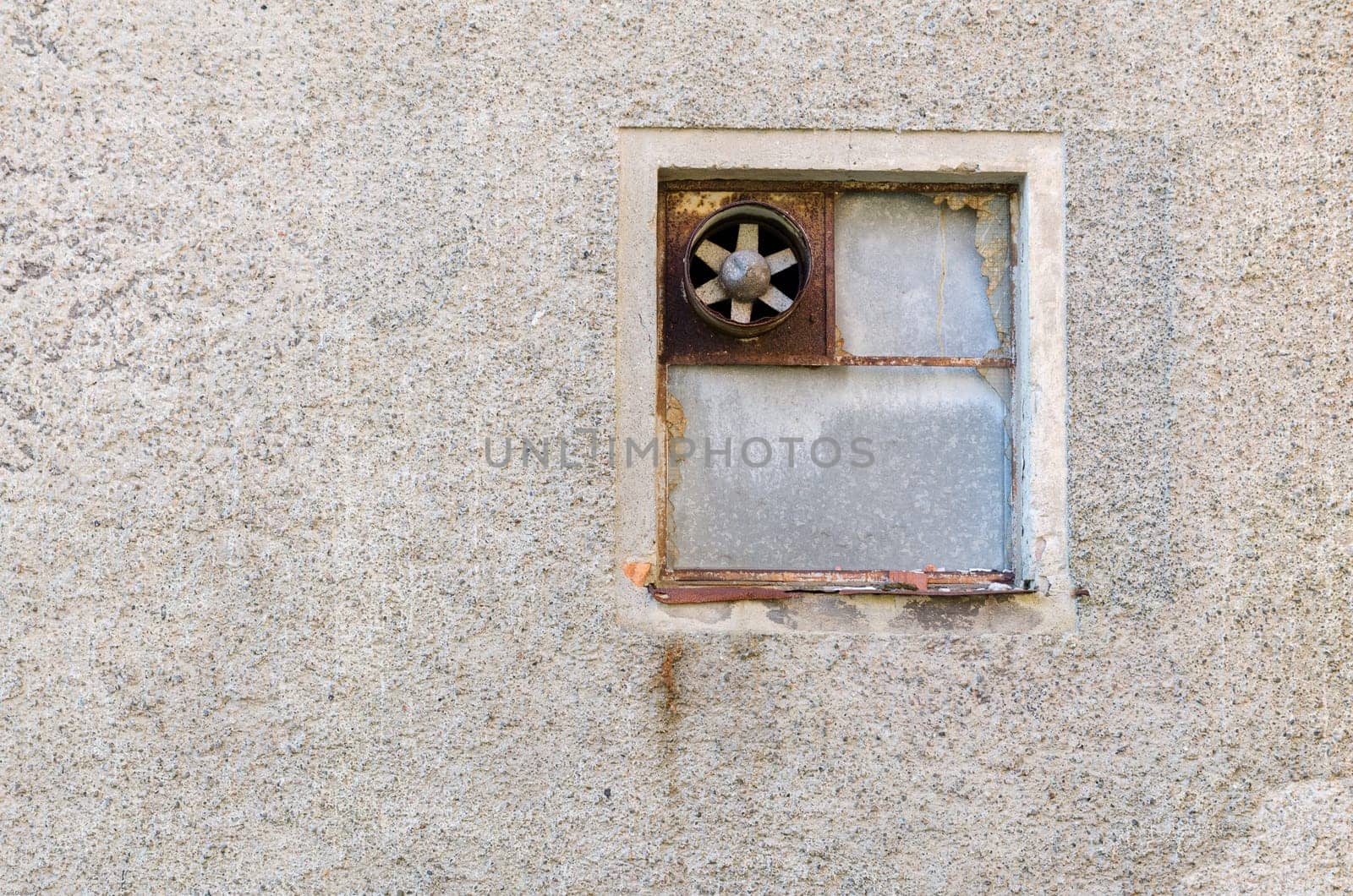 one old ventilation fan on the wall on a very old building