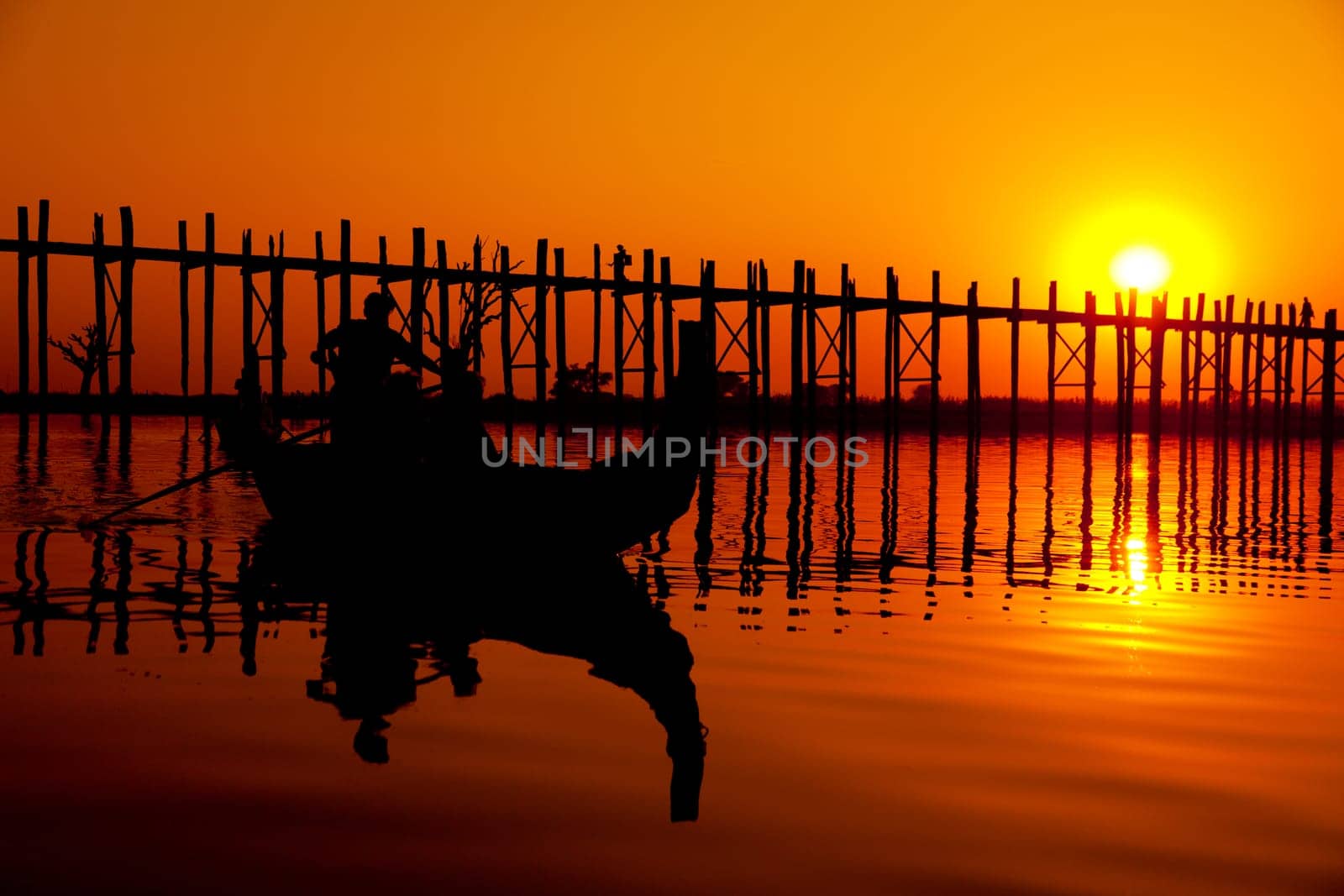 U Bein Bridge at sunset with people crossing Ayeyarwady River, Mandalay, Myanmar