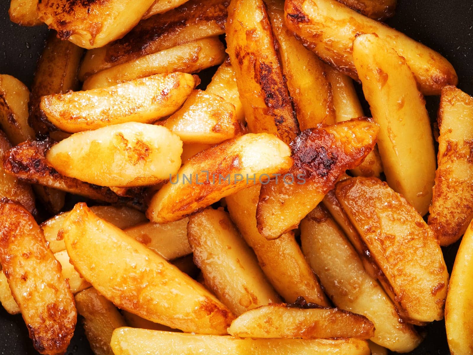 Fried potatos with sugar burn into caramel, close up
