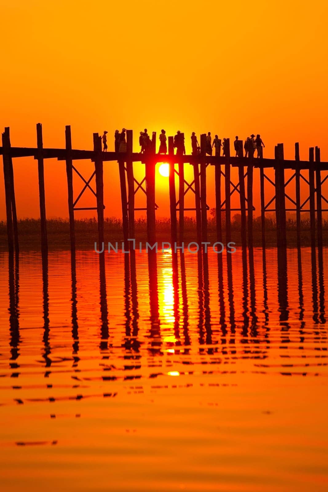 U Bein Bridge at sunset with people crossing Ayeyarwady River, Mandalay, Myanmar